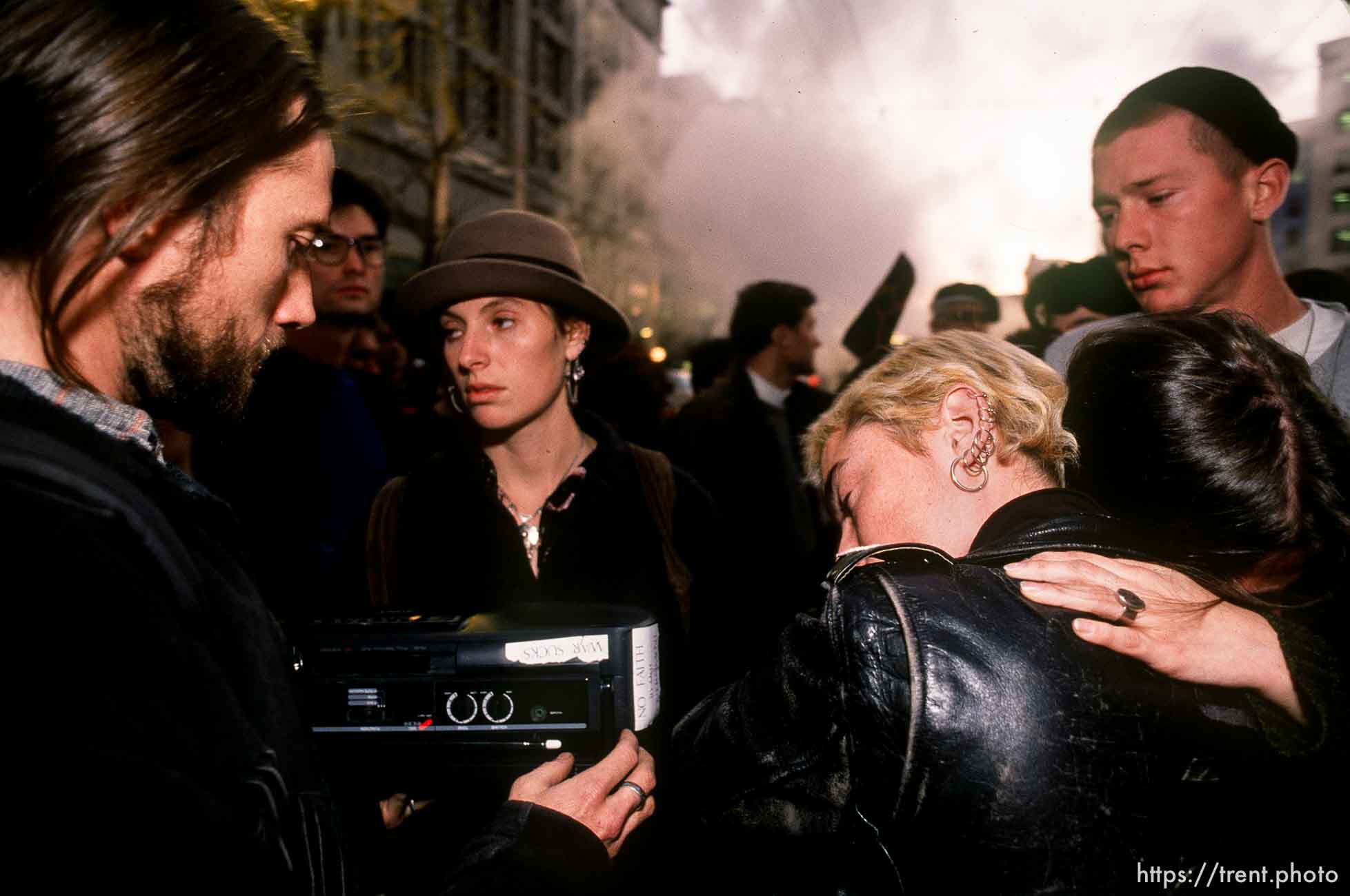 People embrace in sorrow while listening to radio reports about the bombing of Baghdad, which had just begun, on Market Street at Gulf War protest.