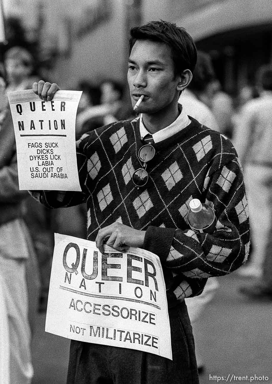 Man holding Queer Nation flier at Gulf War protest.