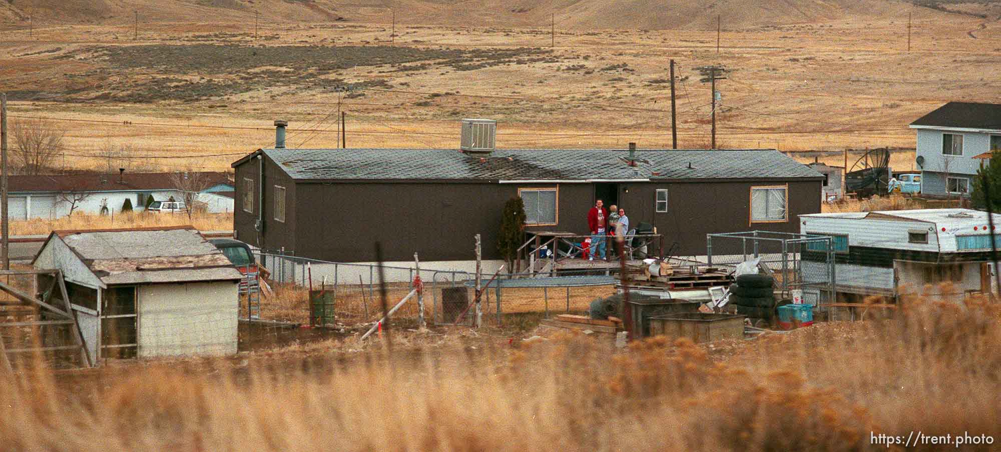 People stand outside their home to watch the Governor's Centennial Train