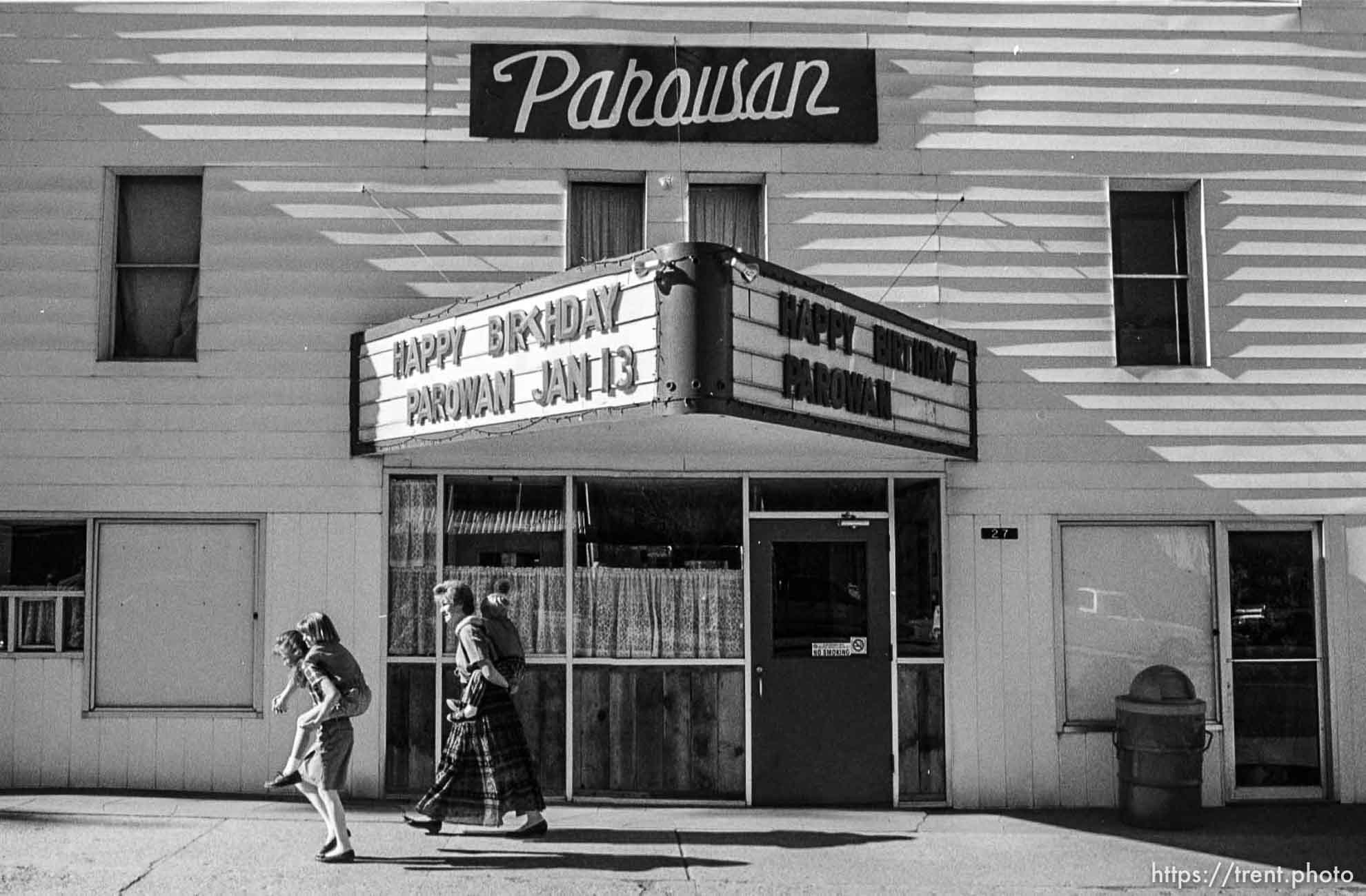 Right to left: Nicole, Ali, Leslie, and Brett Cecil, a Parowan family walk past the Parowan Theater on their way to the dedication ceremony at Heritage Park, Parowan. School busses acting as shuttles from the high school to the park were only half-full as many people opted to walk the five block distance. photo by trent nelson