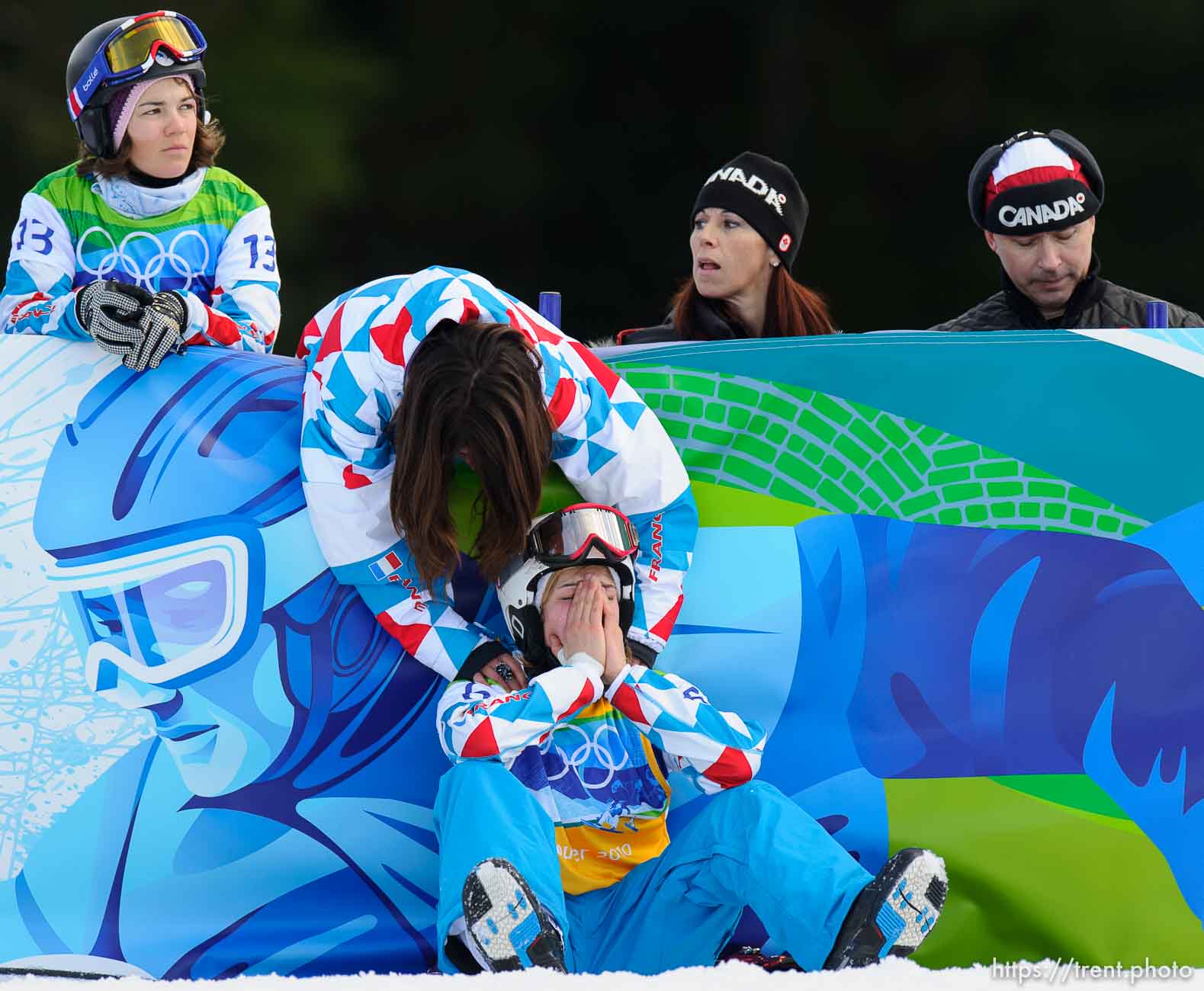 Nelly Moenne Loccoz, France, is comforted after placing 7th in the Ladies' Snowboard Cross, at the XXI Olympic Winter Games in Vancouver, Tuesday, February 16, 2010.