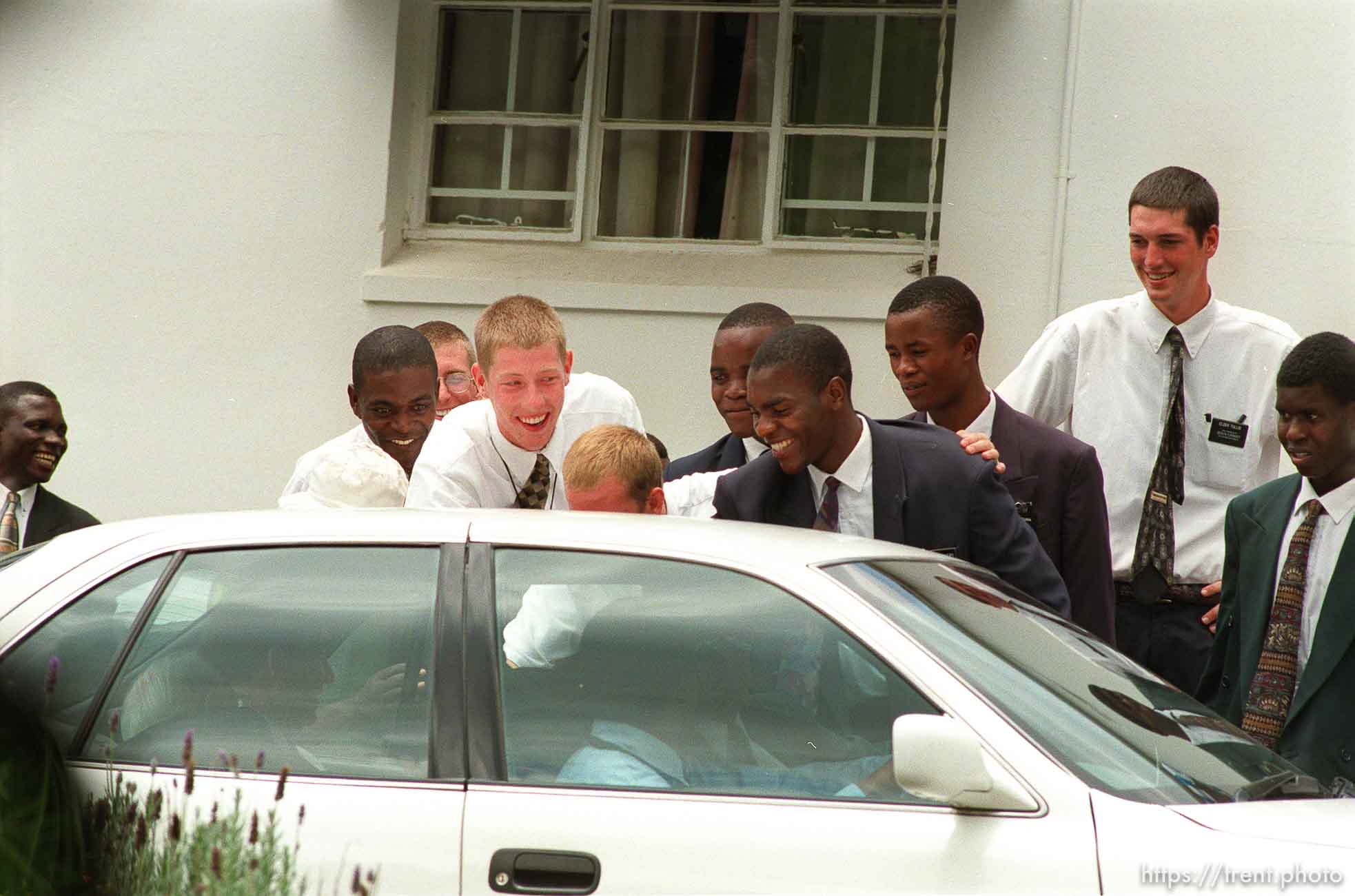 LDS missionaries greet LDS President Gordon B. Hinckley as he tours the mission home in his car.