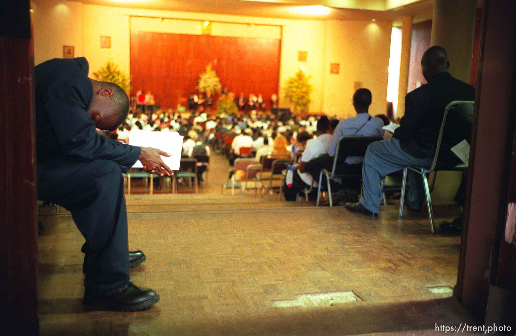 An usher bows his head during the opening prayer at a meeting where LDS President Gordon B. Hinckley spoke in the Zuna PF Building.