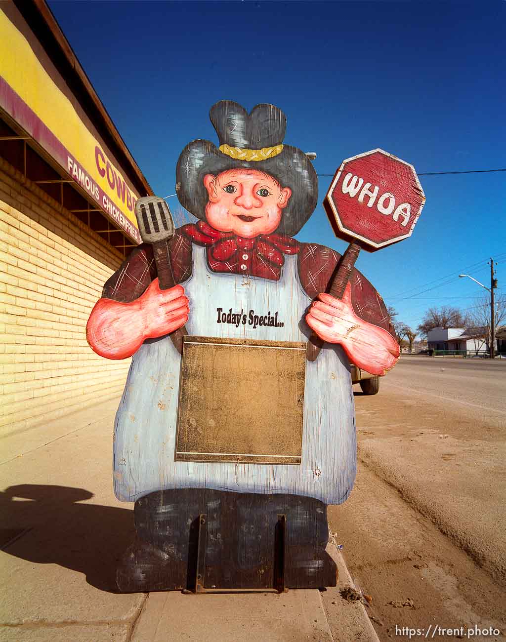 Cowboy cutout in front of roadside cafe.