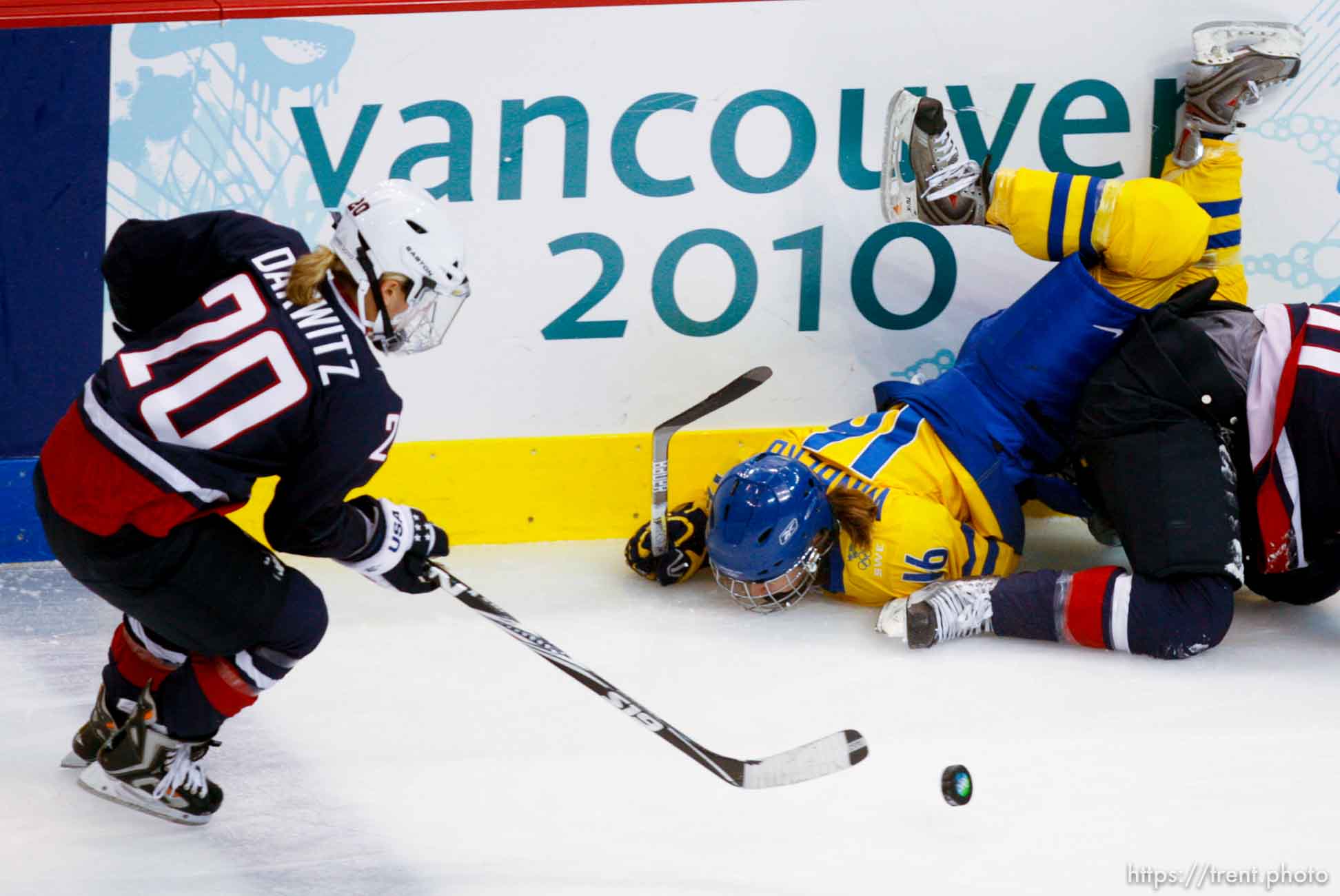 Sweden's Pernilla Winberg flips over USA's Meghan Duggan. USA's Natalie Darwitz at left. USA vs. Sweden, women's hockey, at the XXI Olympic Winter Games in Vancouver, Monday, February 22, 2010.