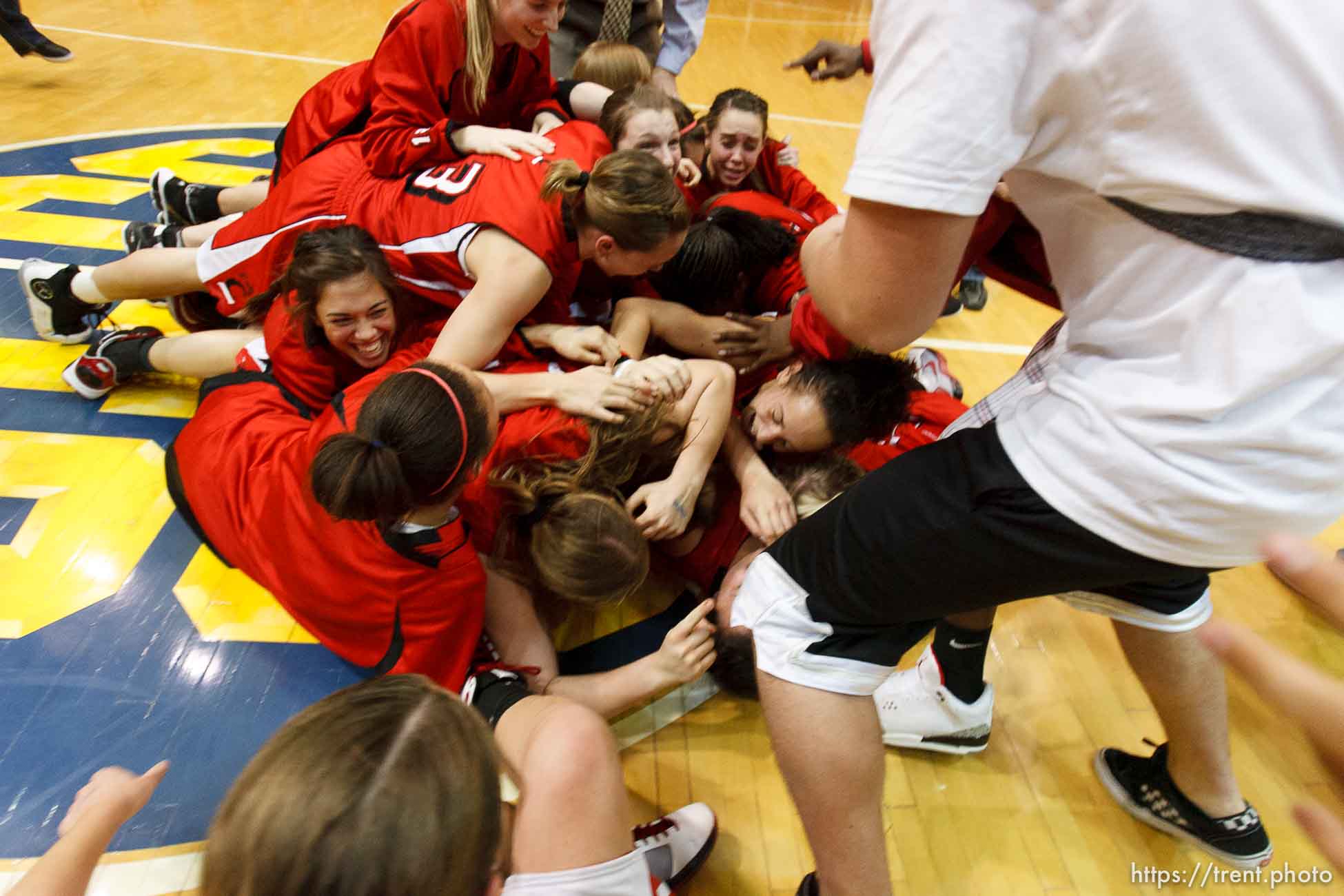 Taylorsville - American Fork players collapse in a dog pile at center court, celebrating their championship win over Riverton. Riverton vs. American Fork High School girls basketball, 5A State Championship game Saturday February 28, 2009 at Salt Lake Community College.