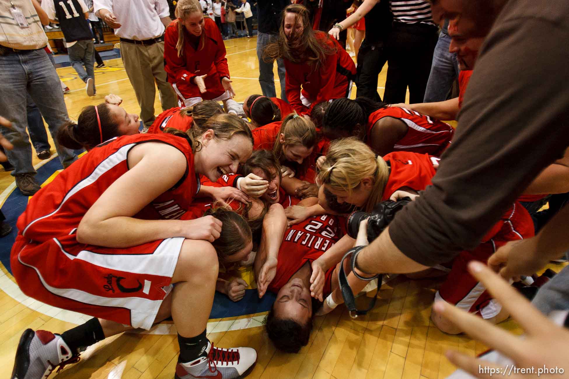 Taylorsville - American Fork players collapse in a dog pile at center court, celebrating their championship win over Riverton. Riverton vs. American Fork High School girls basketball, 5A State Championship game Saturday February 28, 2009 at Salt Lake Community College.