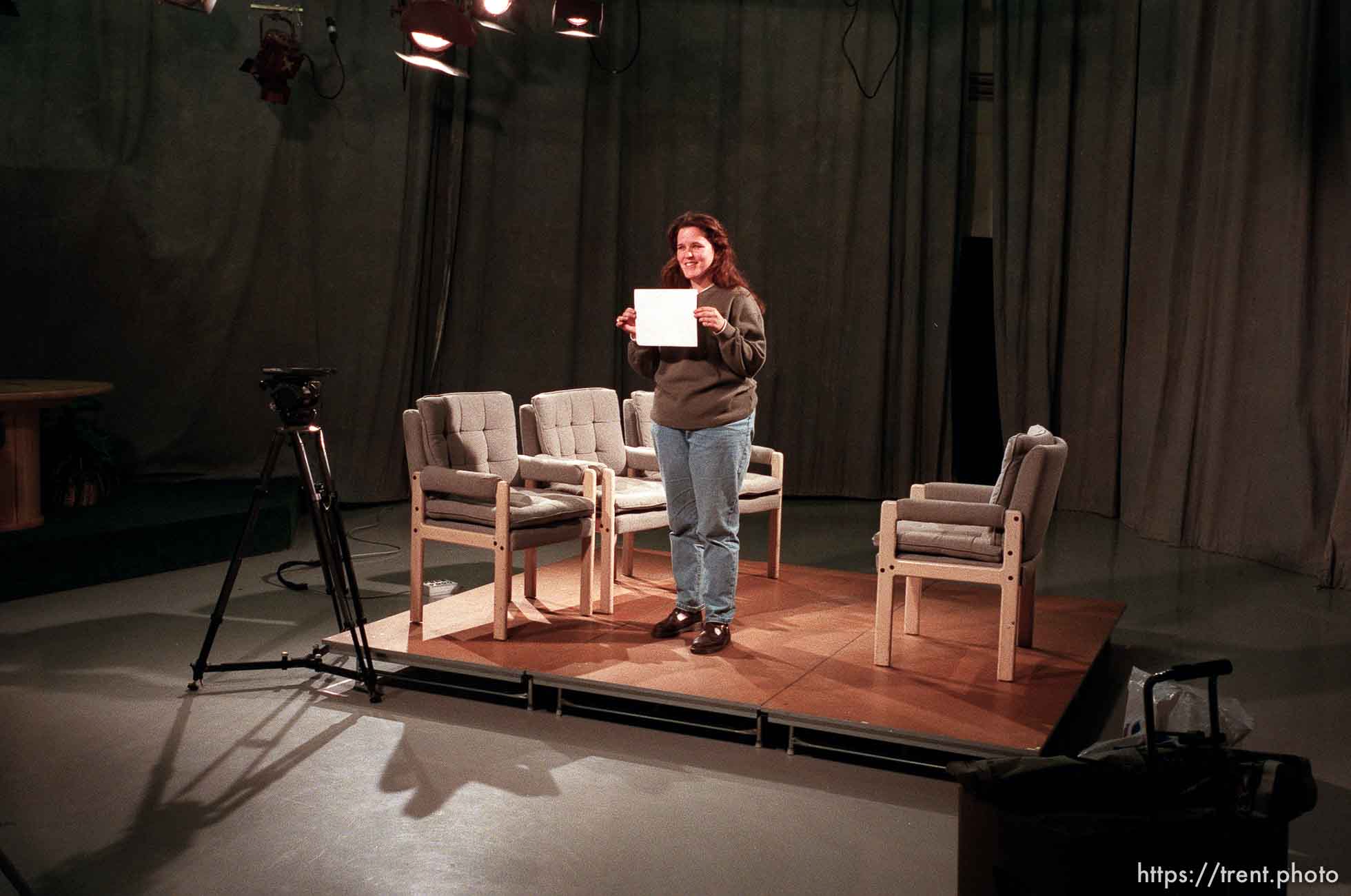 Janelle Riley holds a white card for a camera operator while preparing for a taping at KBYU TV.