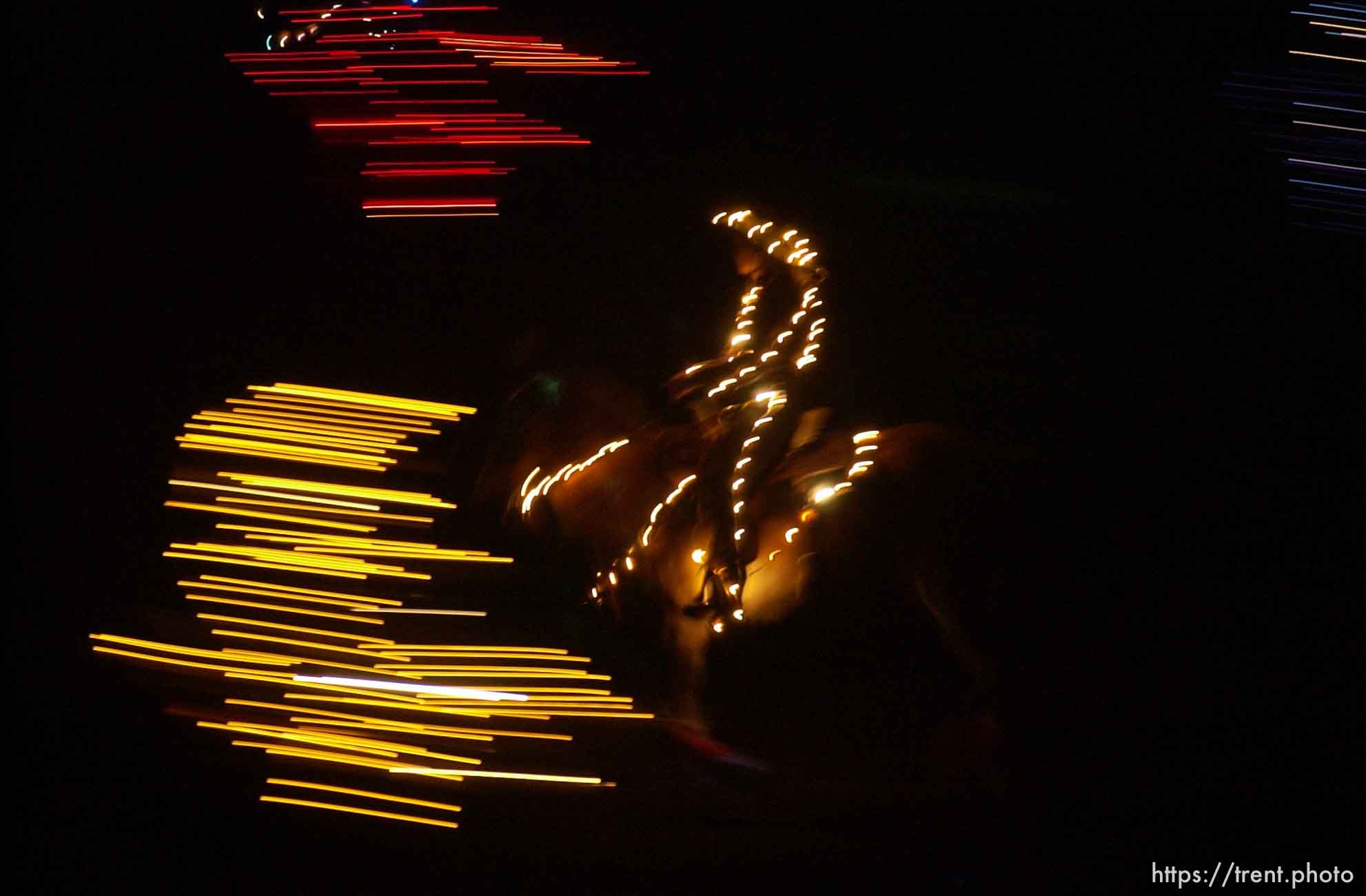 Riders covered in electric lights ride their horses as the opening ceremony to the Olympic Command Performance Rodeo Saturday night,  Davis County Legacy Center, 2002 Olympic Winter Games.; 02.09.2002, 8:19:45 PM