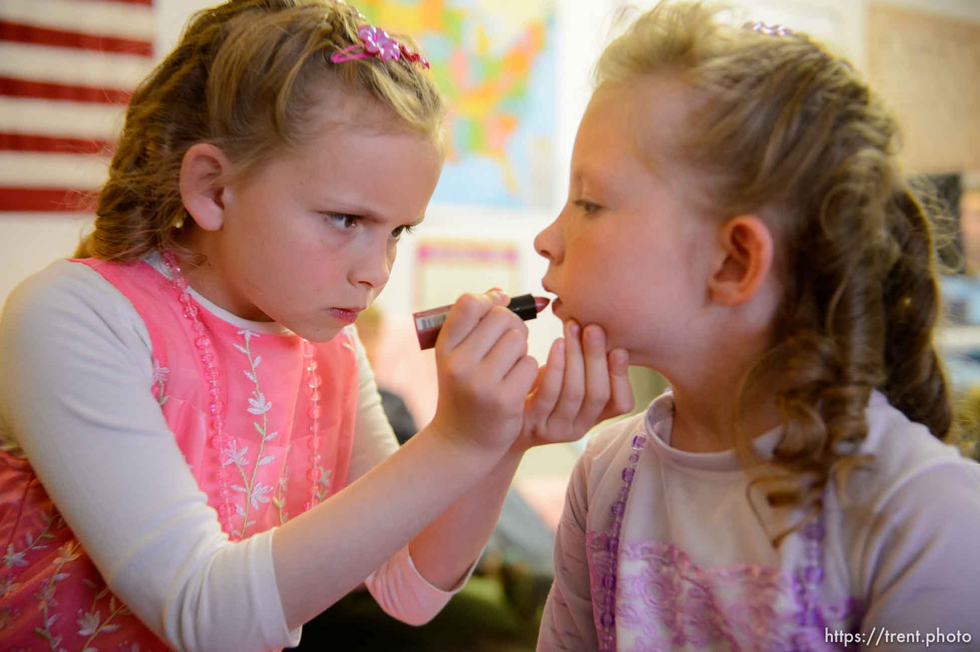 (Trent Nelson | The Salt Lake Tribune)  
A princess party was thrown for several young FLDS girls in Colorado City, Ariz., Friday March 16, 2018, as a reward for reading books. Before the party, Kathy Bistline puts lipstick on her sister Lolly during their first experience with makeup.