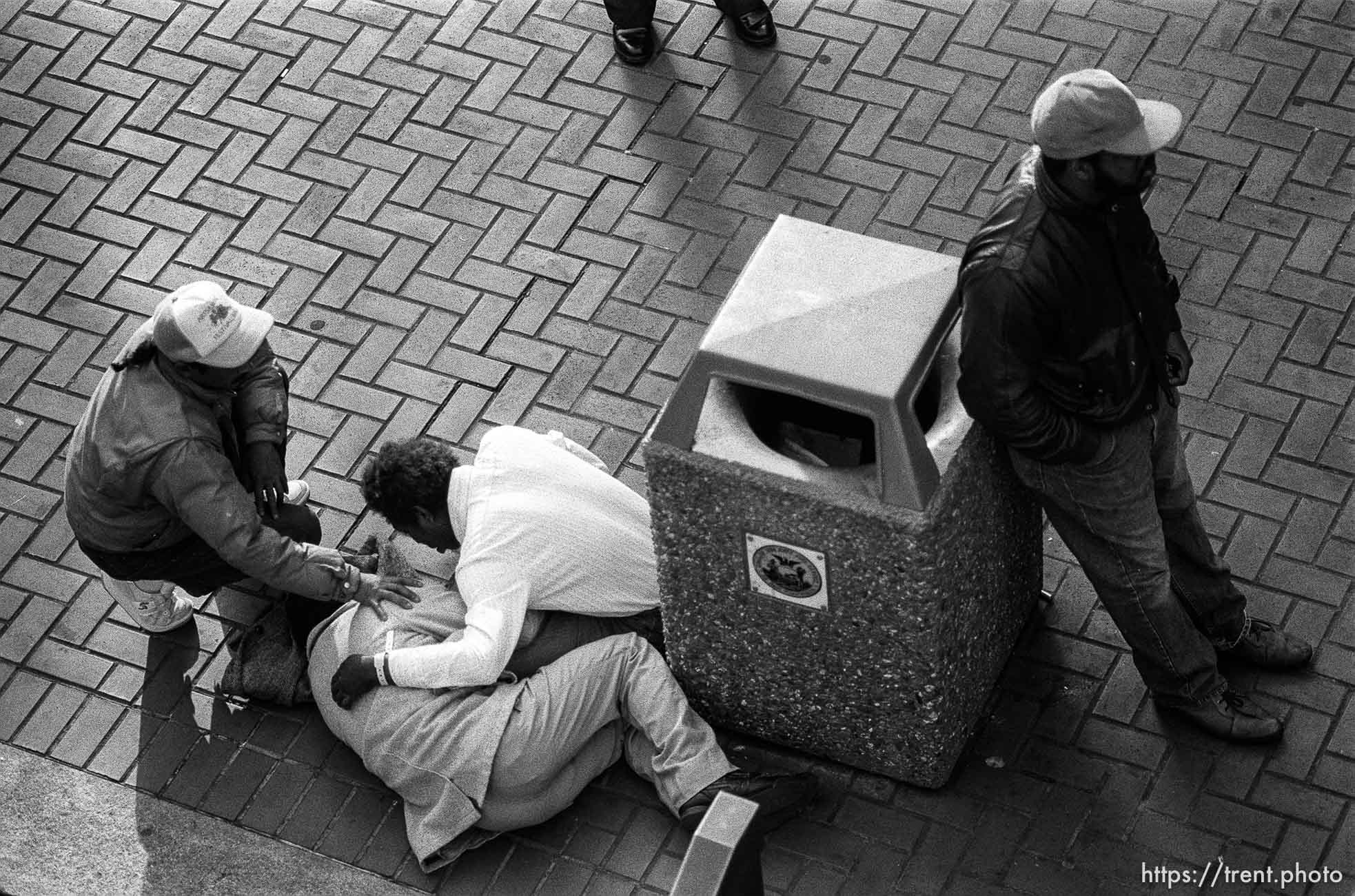 People checking on man who collapsed.