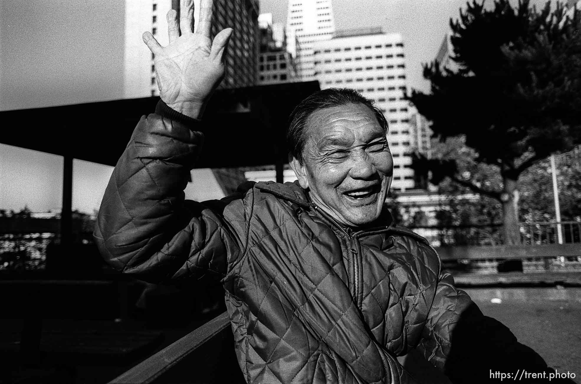 Old asian man waving.