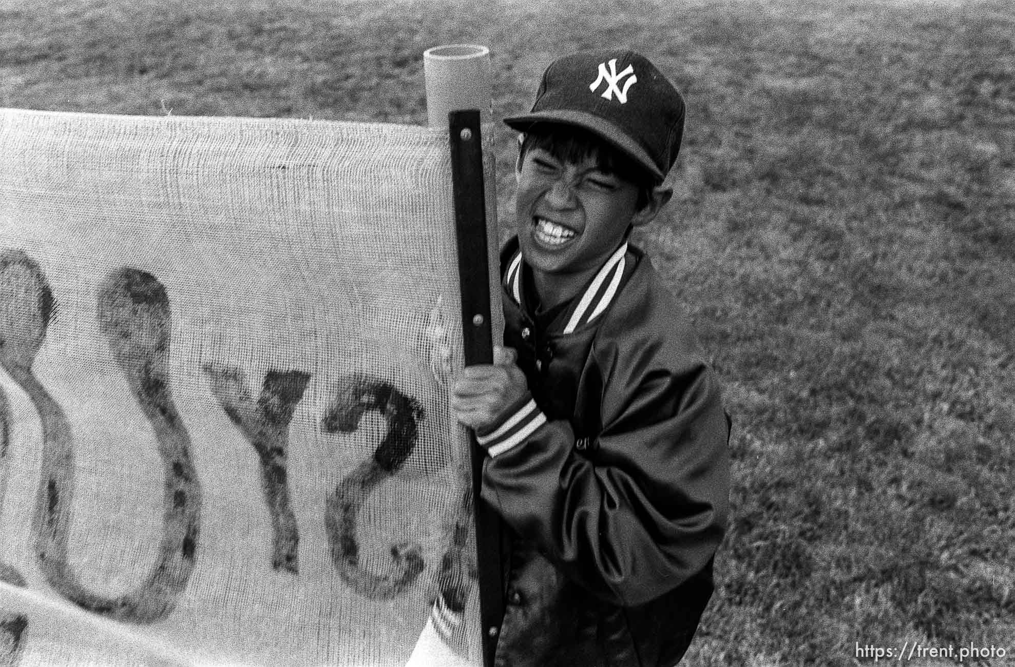 Kid pulling up fence at Yankees game