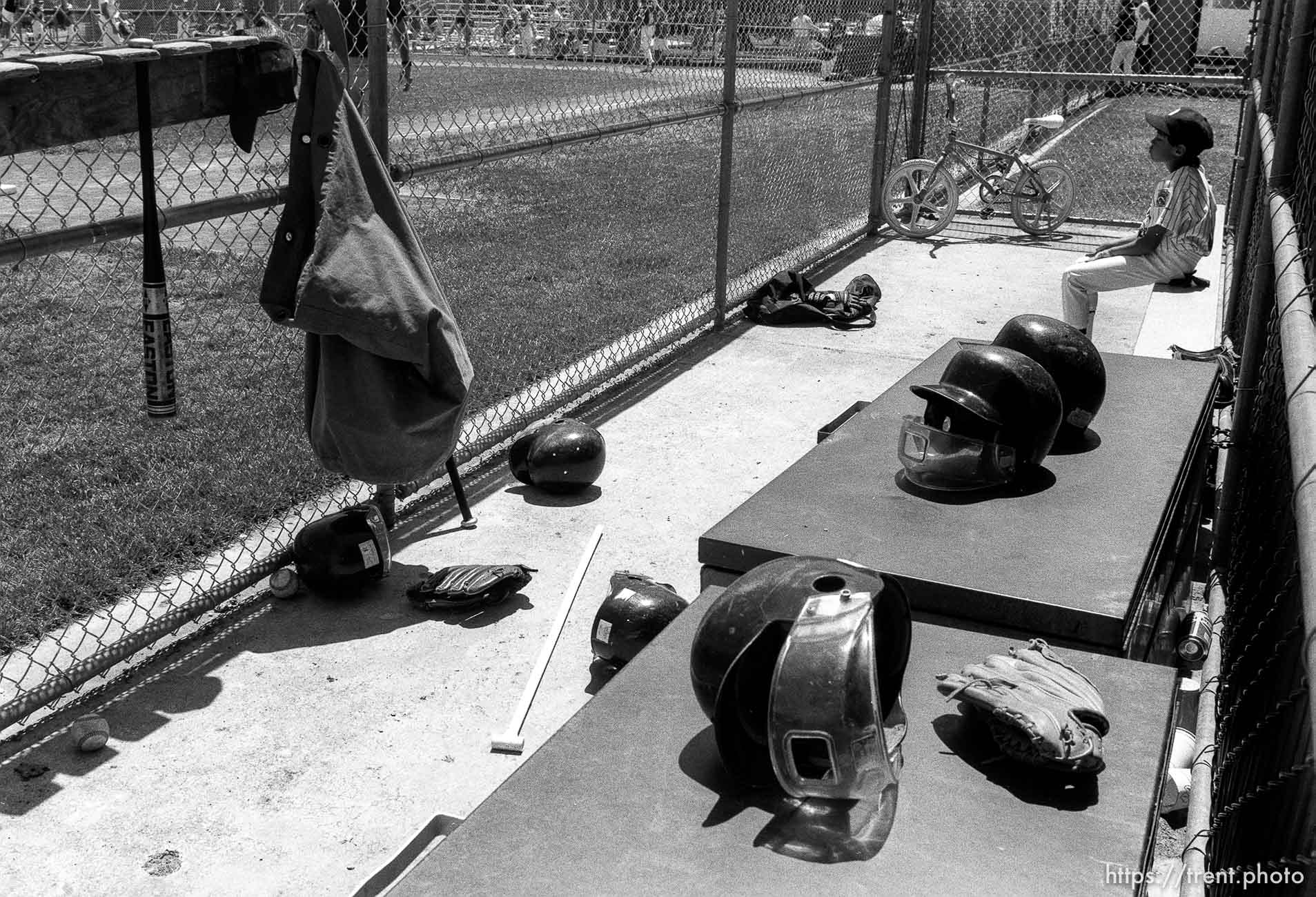 Kid in dugout full of gear at Yankee's game.