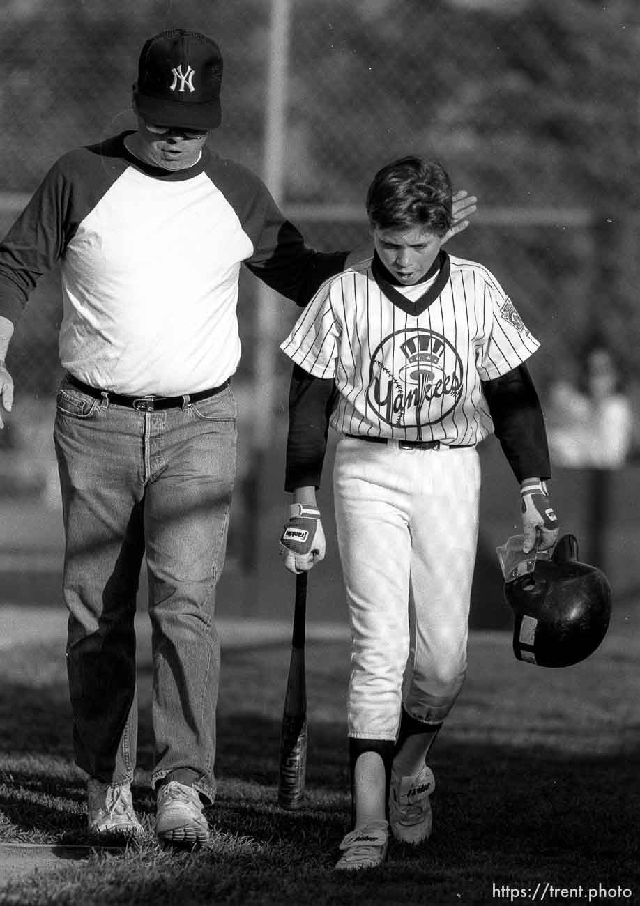 Coach pats player on the back at Yankees game.