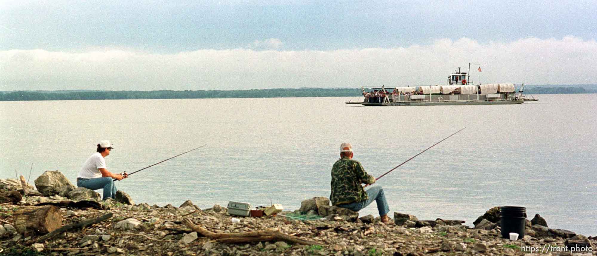 Fishermen on the Iowa side of the Mississippi watch a ferry carrying wagons which will cross Iowa in a three-week trip to Winter Quarters. photo by trent nelson