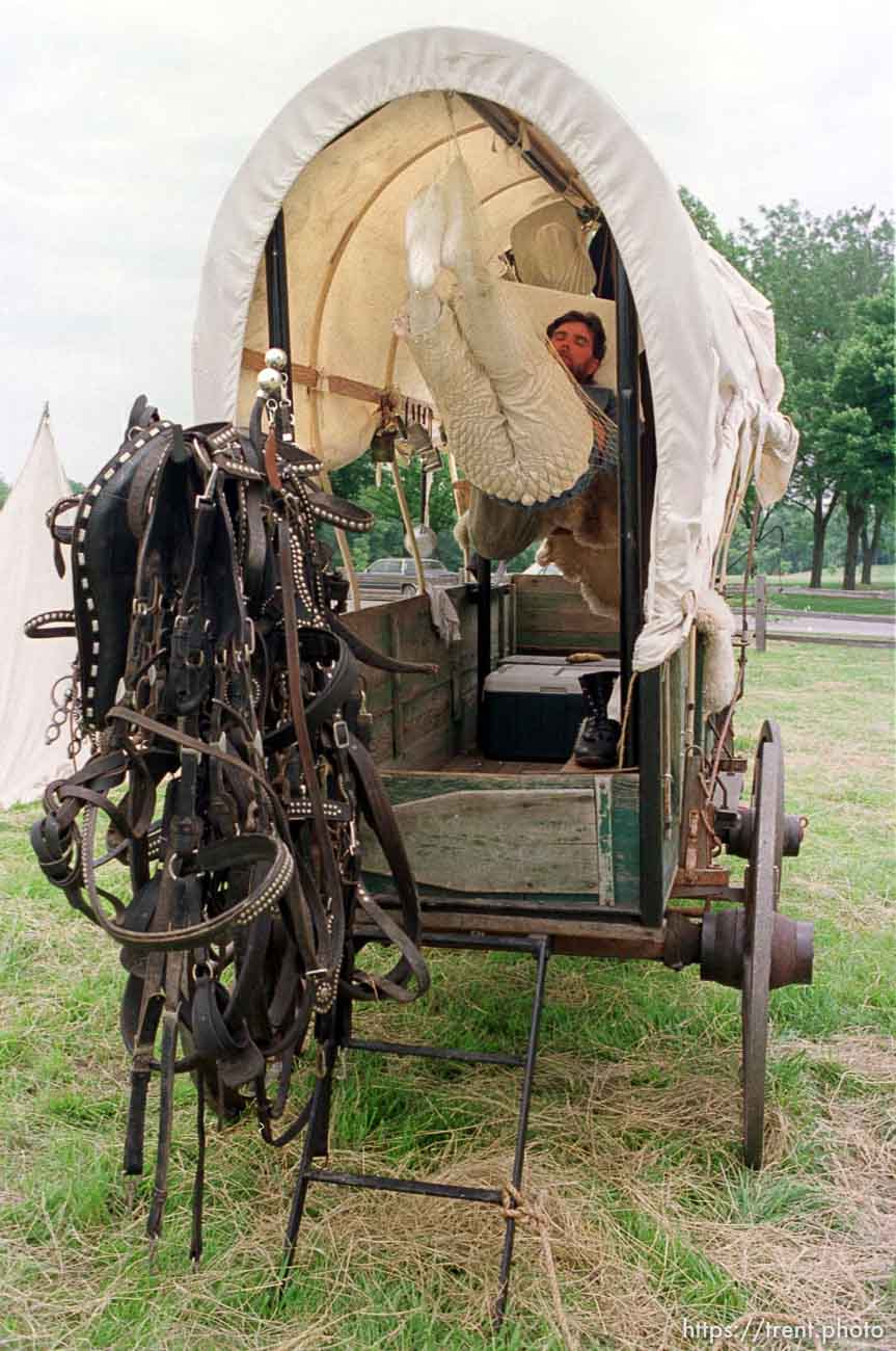 Jeff England gets some sleep in a hammock tied onto his wagon in preparation for the JL2 Authentic Wagon Train's sunrise journey by ferry across the Mississippi River from Nauvoo, IL. photo by trent nelson