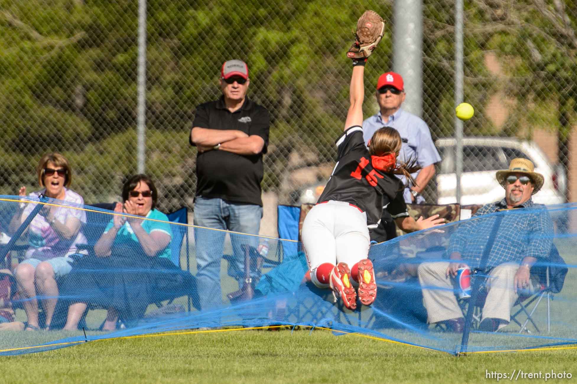 Trent Nelson  |  The Salt Lake Tribune
Uintah's Morgan Reynalds dives over the fence after a home run ball as Spanish Fork defeats Uintah High School in the Class 4A softball state title game in Taylorsville, Thursday May 25, 2017.