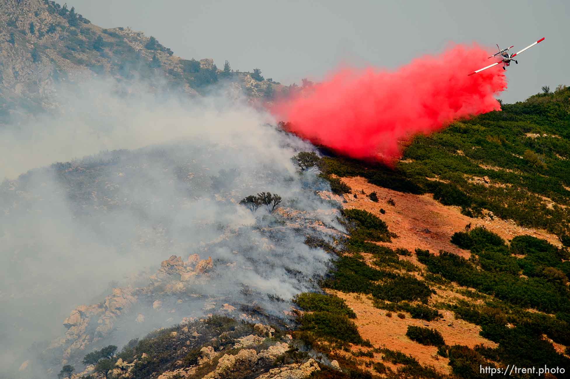 (Trent Nelson | The Salt Lake Tribune)  A plane makes a drop on a fire at the mouth of Weber Canyon, Tuesday September 5, 2017.