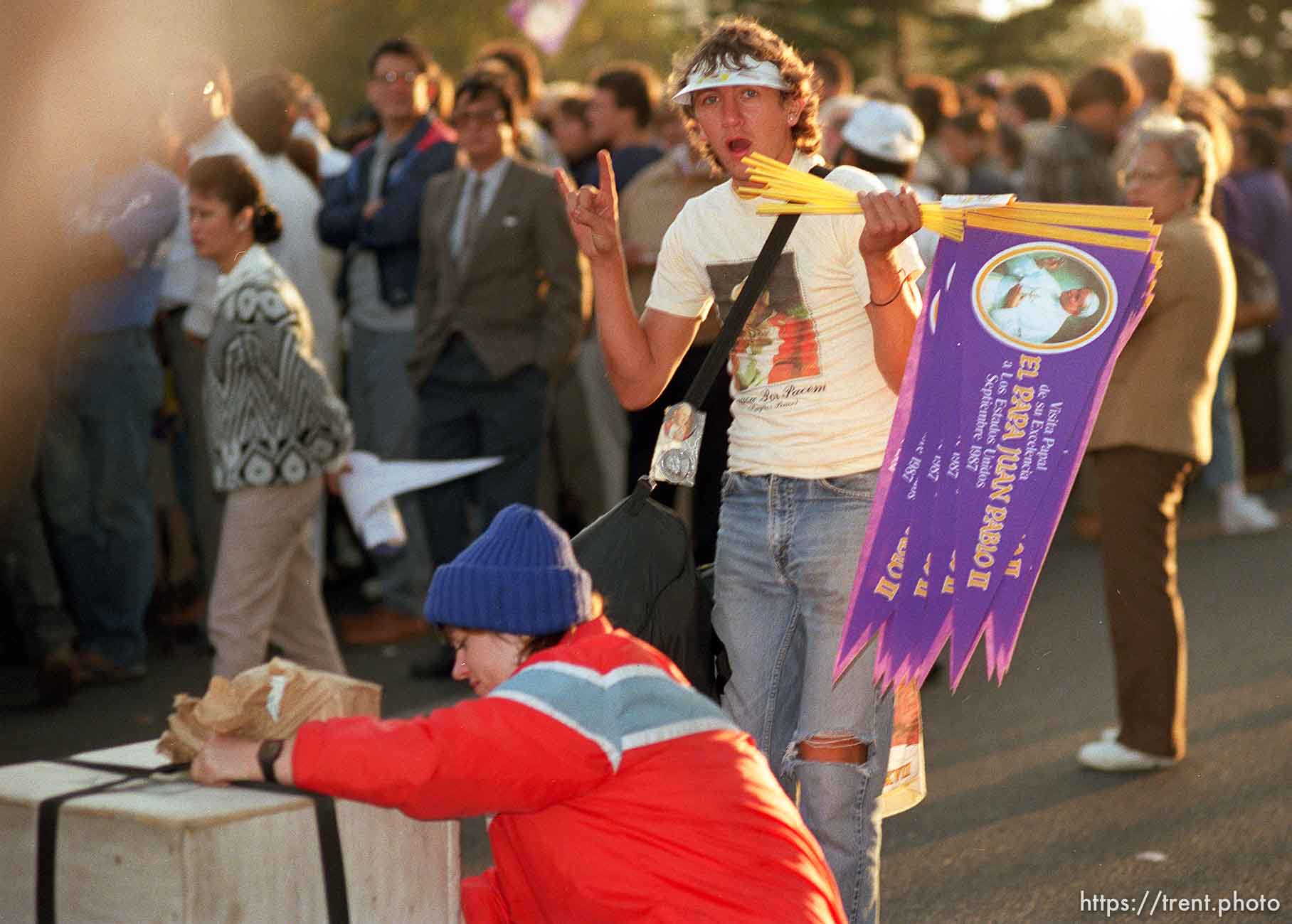 Guy selling Pope banners makes the devil heavy metal sign to me at the Pope's visit.