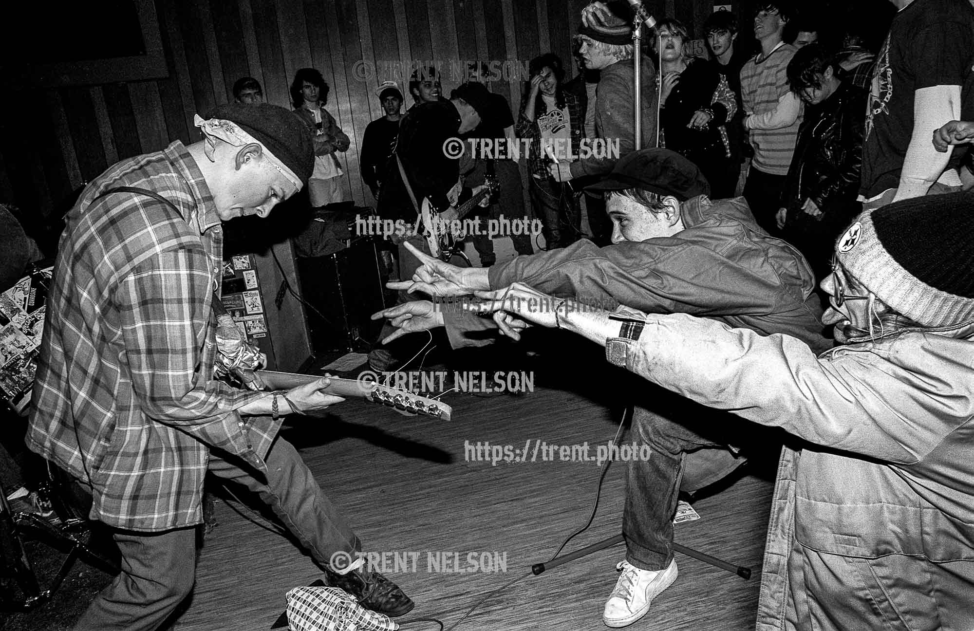 Operation Ivy fans jokingly taunt guitarist Tim Armstrong during a performance at the Veterans Hall in Davis, California, 1987.
