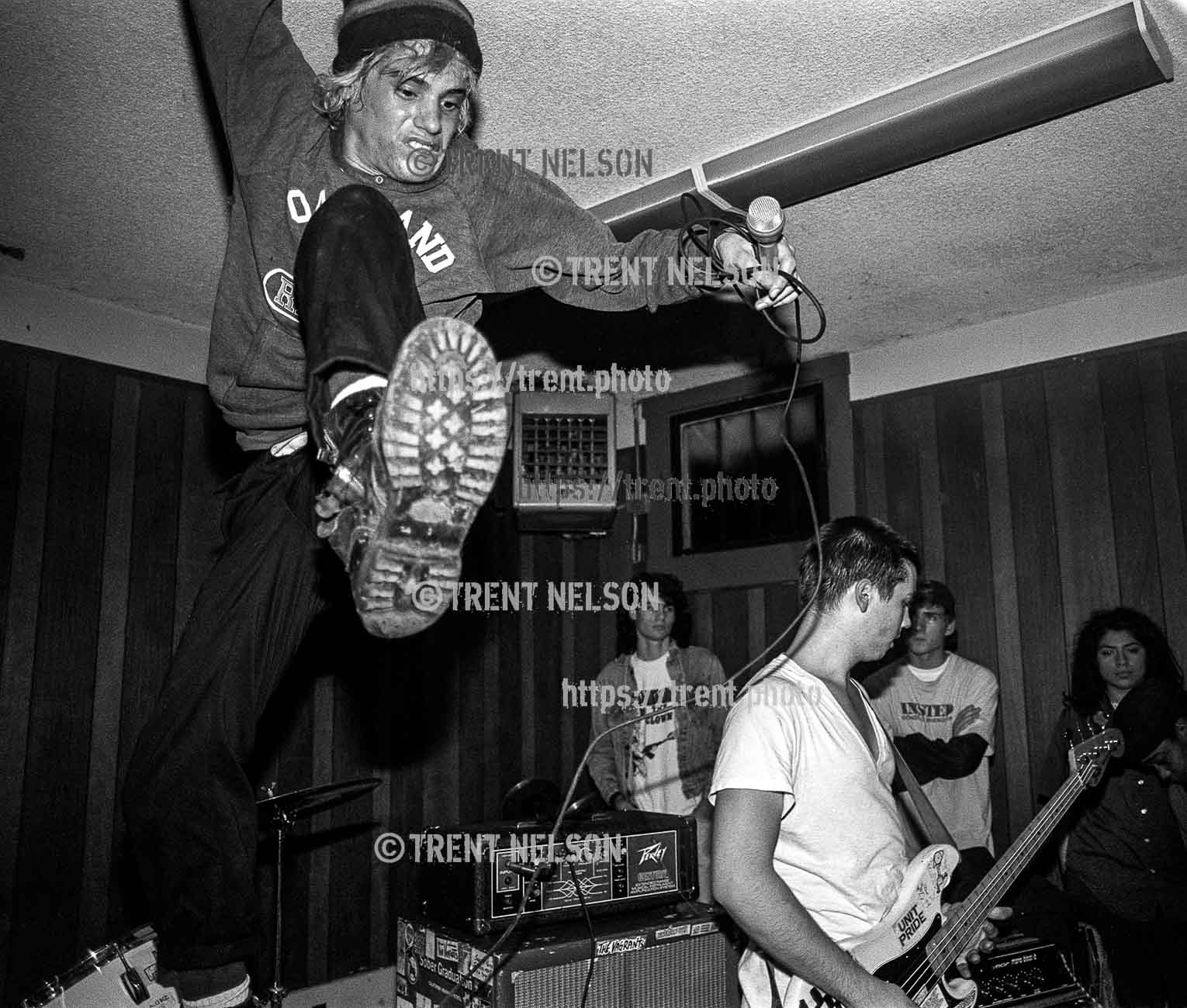 Operation Ivy's Jesse Michaels leaps from the drum kit during a performance at the Veterans Hall in Davis, California, 1987. Matt Freeman at right.