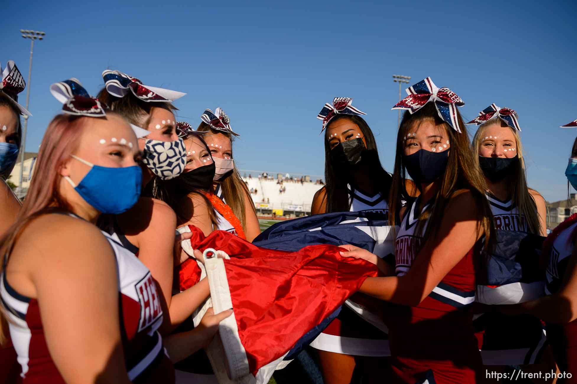 (Trent Nelson  |  The Salt Lake Tribune) Herriman cheerleaders hold a flag during the National Anthem while hosting Davis High School football, in Herriman on Thursday, Aug. 13, 2020.