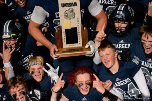 (Trent Nelson  |  The Salt Lake Tribune) Corner Canyon's Jackson Light holds the trophy while celebrating with teammates after the 6A state football championship game against Lone Peak at Cedar Valley High School in Eagle Mountain on Friday, Nov. 20, 2020.