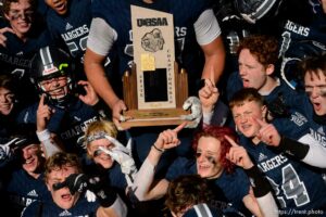 (Trent Nelson  |  The Salt Lake Tribune) Corner Canyon's Jackson Light holds the trophy while celebrating with teammates after the 6A state football championship game against Lone Peak at Cedar Valley High School in Eagle Mountain on Friday, Nov. 20, 2020.