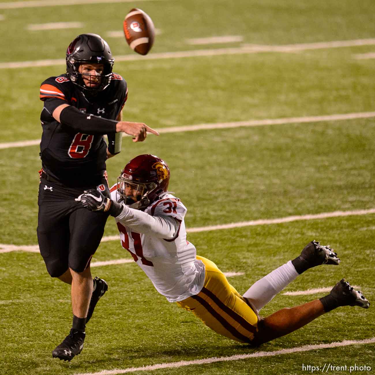 (Trent Nelson  |  The Salt Lake Tribune) Utah Utes quarterback Jake Bentley (8) tries to get the ball away as USC Trojans linebacker Hunter Echols (31) reaches out, as the Utah Utes host the USC Trojans, NCAA football at Rice-Eccles Stadium in Salt Lake City on Saturday, Nov. 21, 2020.