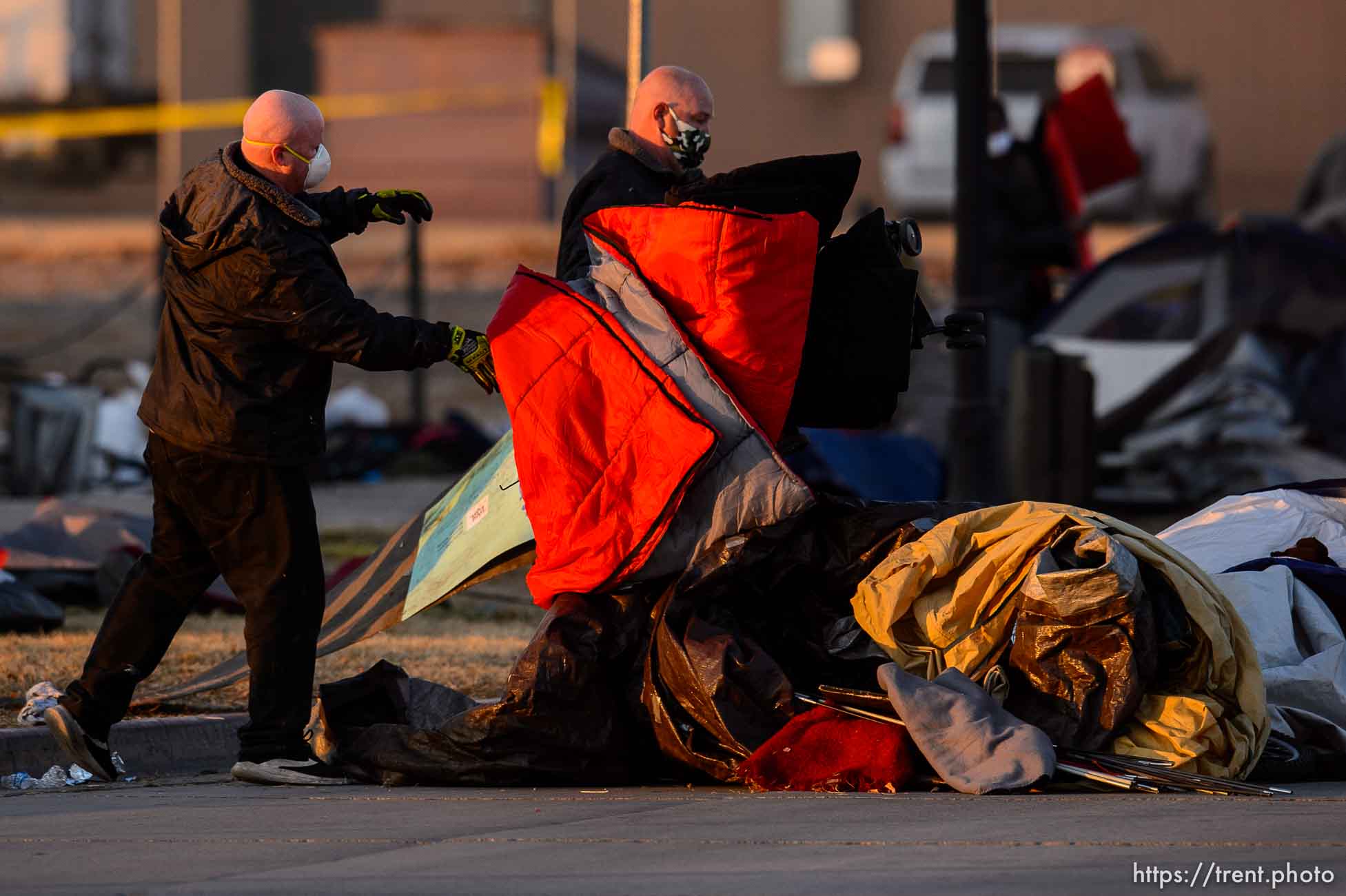 (Trent Nelson  |  The Salt Lake Tribune) Workers throw sleeping bags, tents, and other items into the street during a clean up of a campsite in the Rio Grande area of Salt Lake City on Wednesday, Dec. 9, 2020.