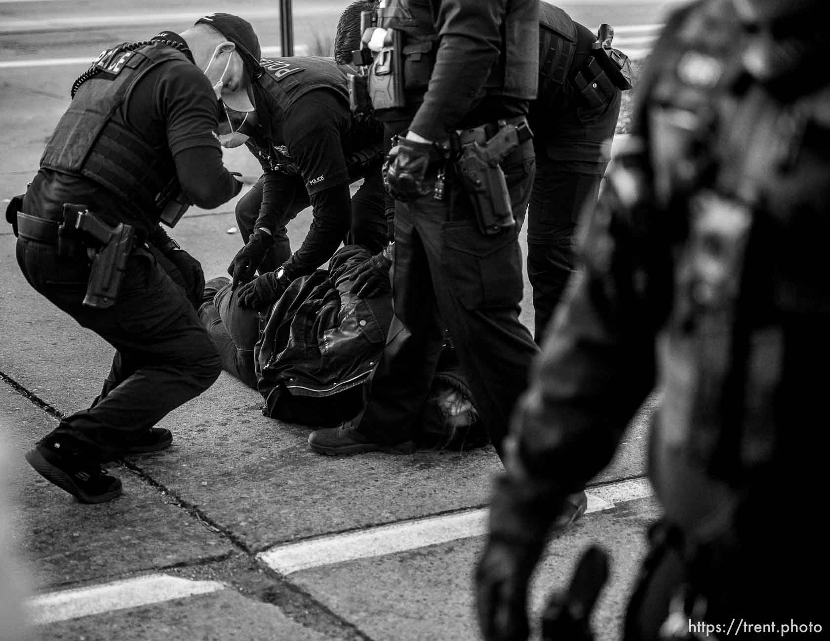 (Trent Nelson  |  The Salt Lake Tribune) Salt Lake City police officers working the cleanup of a series of campsites in Salt Lake City on Wednesday, Dec. 9, 2020. An activist is arrested after a group stood in front of a police car, not allowing it to pass.