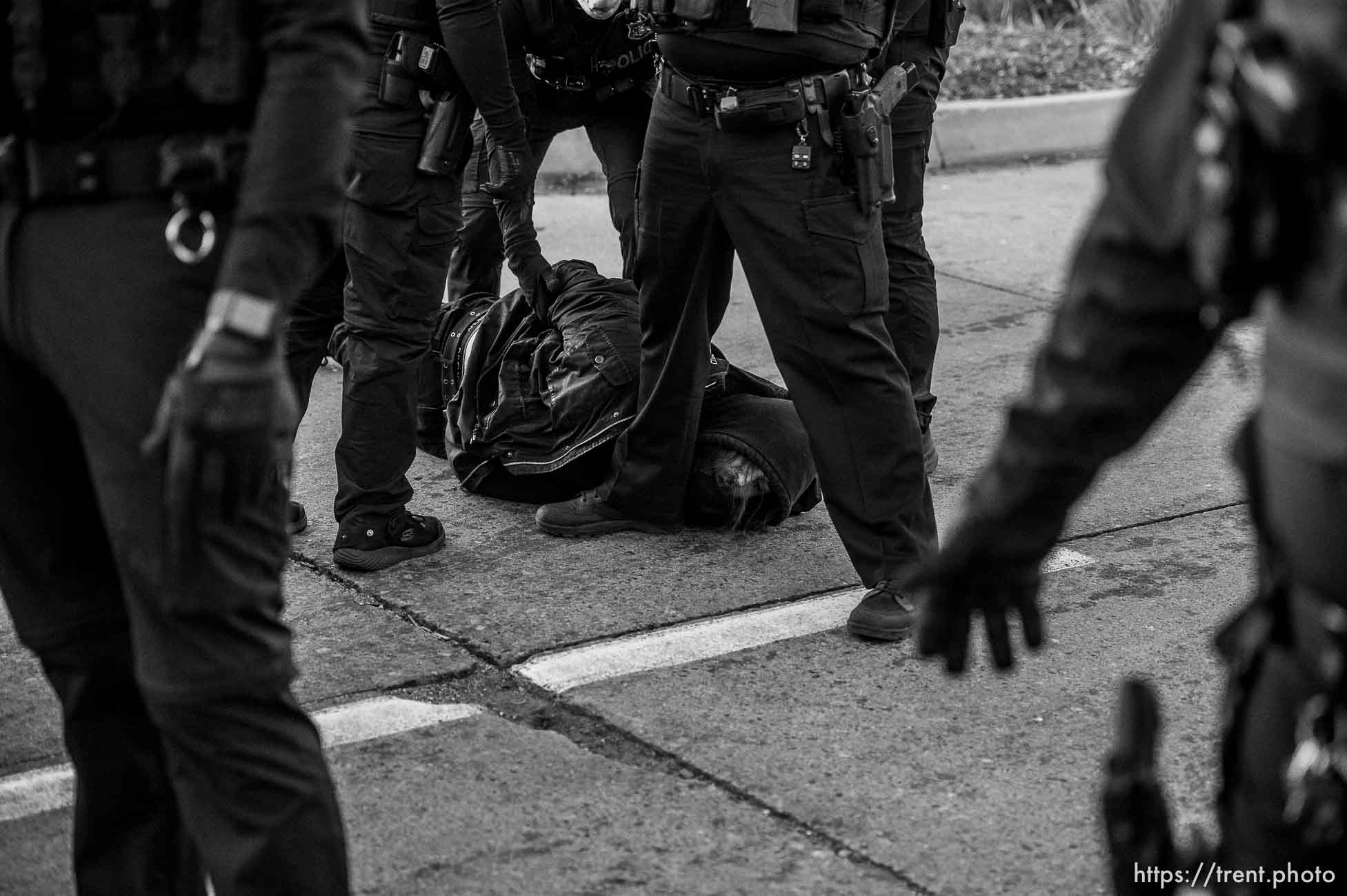 (Trent Nelson  |  The Salt Lake Tribune) Salt Lake City police officers working the cleanup of a series of campsites in Salt Lake City on Wednesday, Dec. 9, 2020. An activist is arrested after a group stood in front of a police car, not allowing it to pass.