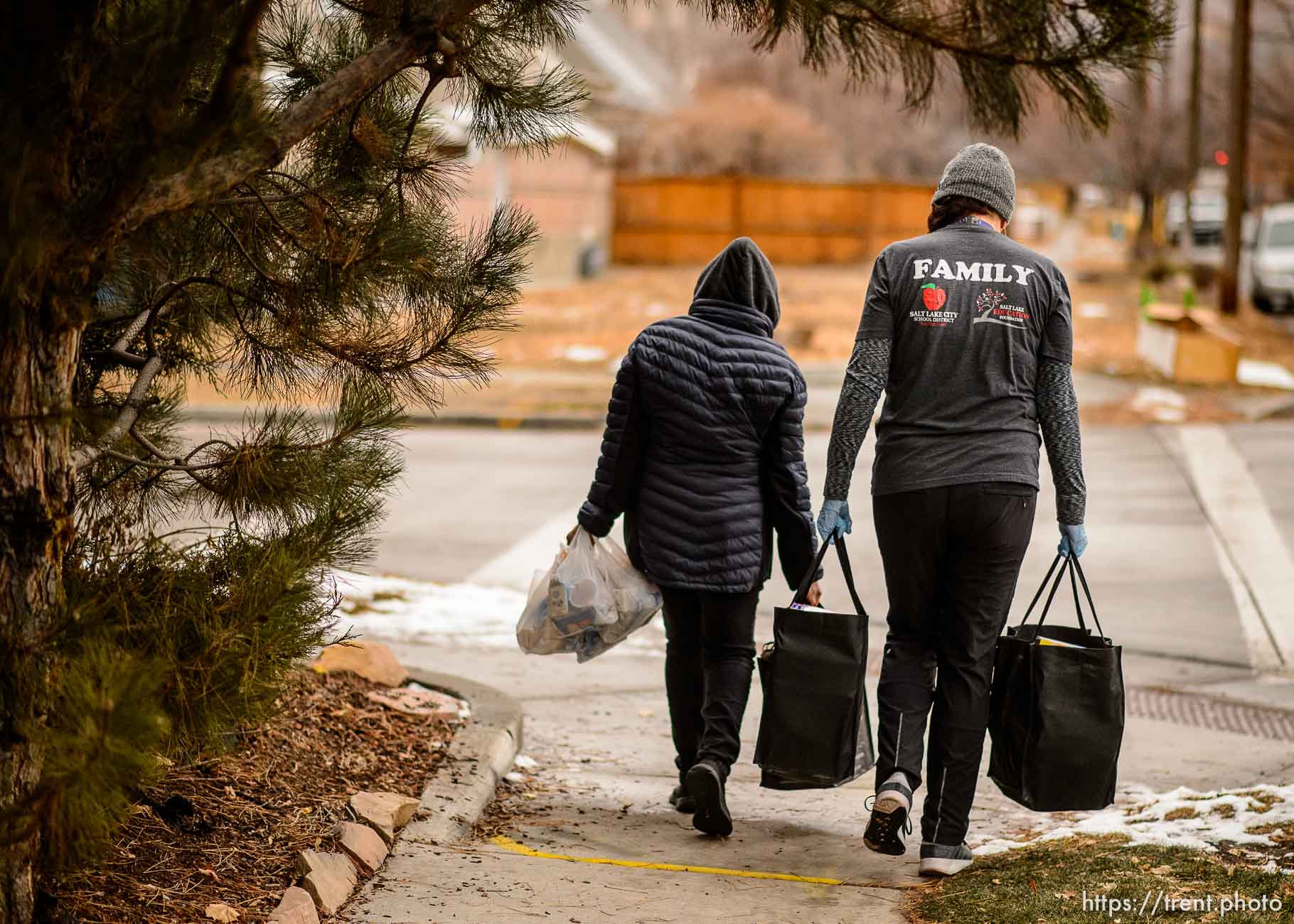 (Trent Nelson  |  The Salt Lake Tribune) Victoria Palauni, right, carries bags of food for a mother in need in Salt Lake City on Thursday, Dec. 17, 2020. Palauni is the coordinator at the Community Learning Center at Liberty Elementary.