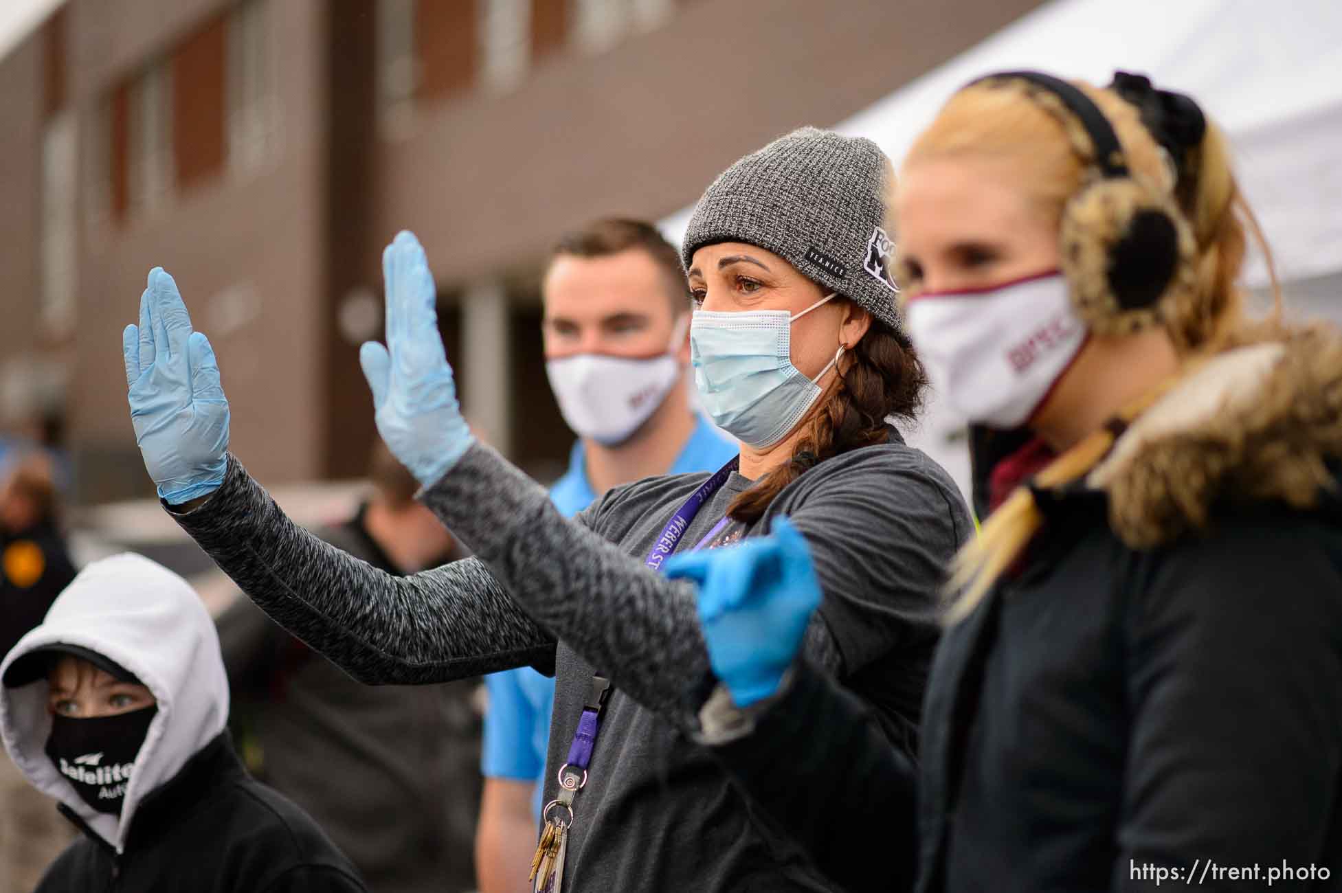 (Trent Nelson  |  The Salt Lake Tribune) Victoria Palauni waves to drivers lined up for food at Liberty Elementary in Salt Lake City on Thursday, Dec. 17, 2020.