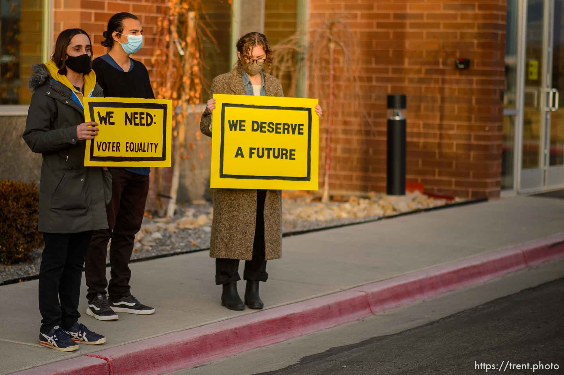 (Trent Nelson  |  The Salt Lake Tribune) Mark Lavelle, David Alonso, and Emma Lowe rally in front of the office of Rep. Burgess Owens, R-Utah, in West Jordan on Thursday, Jan. 21, 2021. The event is part of a nationwide effort by the Sunrise Movement, a national youth- and millenial-lead activist group, aiming to achieve racial, economic, and climate justice through the Green New Deal.