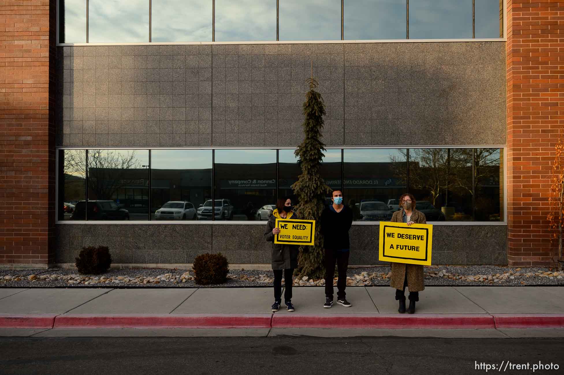 (Trent Nelson  |  The Salt Lake Tribune) Mark Lavelle, David Alonso, and Emma Lowe rally in front of the office of Rep. Burgess Owens, R-Utah, in West Jordan on Thursday, Jan. 21, 2021. The event is part of a nationwide effort by the Sunrise Movement, a national youth- and millenial-lead activist group, aiming to achieve racial, economic, and climate justice through the Green New Deal.