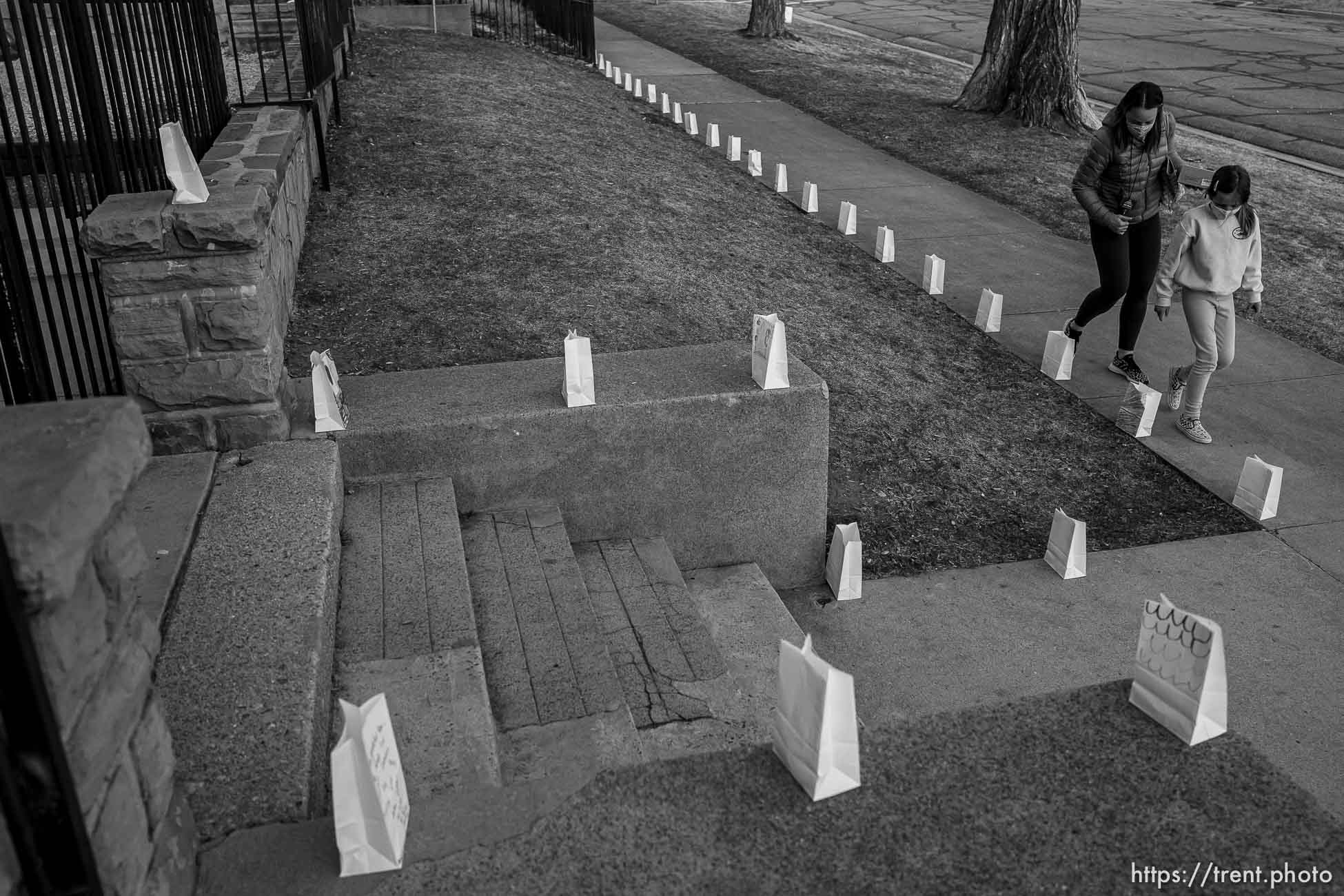 (Trent Nelson  |  The Salt Lake Tribune) Jen and Helena Voros check on the 500 luminarias put out by students and teachers at the McGillis School in Salt Lake City, on Wednesday, March 17, 2021. The luminarias each have a message of gratitude and hope or a reflection on the past year's pandemic