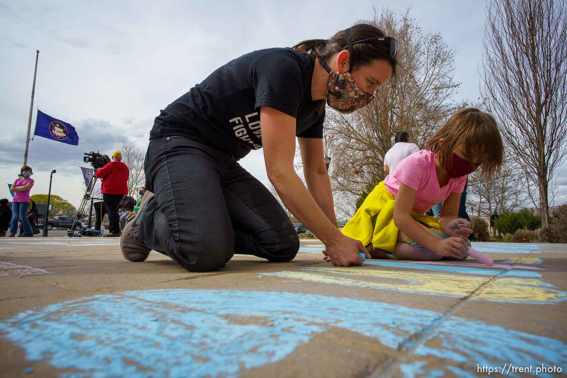 (Trent Nelson  |  The Salt Lake Tribune) Emily and Ellie Thompson write the names of victims in the recent Atlanta shootings in chalk at Salt Lake Community College during a Peace & Justice Vigil on Friday, March 19, 2021.