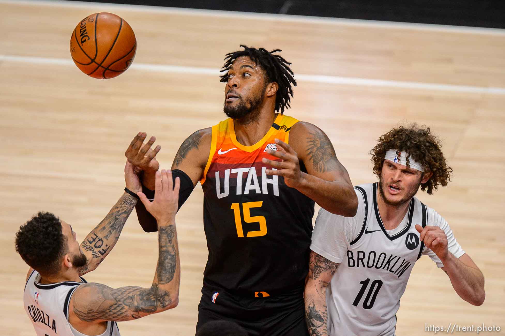 (Trent Nelson  |  The Salt Lake Tribune) Utah Jazz center Derrick Favors (15) looks for the rebound as the Utah Jazz host the Brooklyn Nets, NBA basketball in Salt Lake City on Wednesday, March 24, 2021. At left is Brooklyn Nets guard Chris Chiozza (4) and right is Brooklyn Nets guard Tyler Johnson (10).