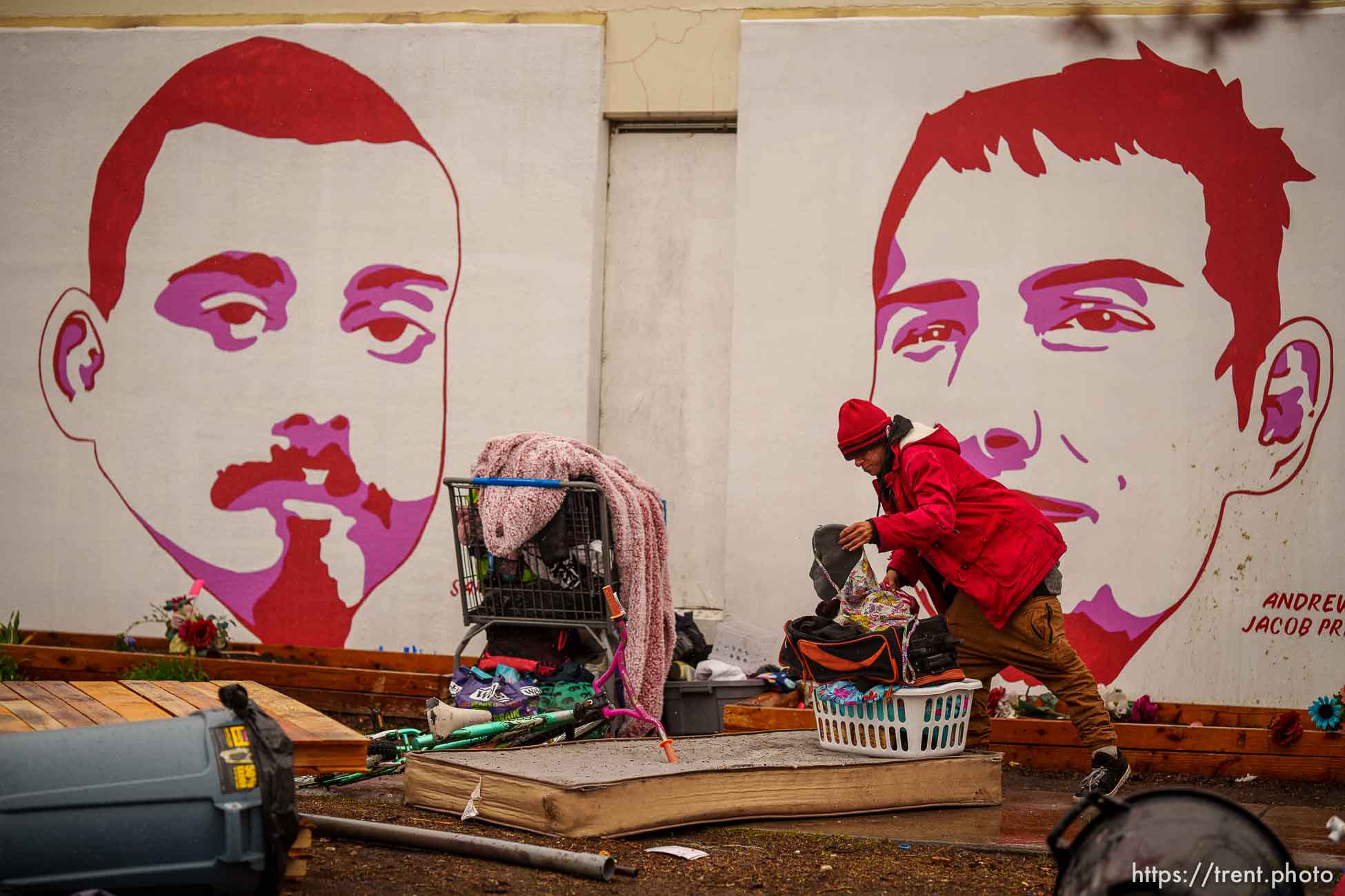 (Trent Nelson  |  The Salt Lake Tribune) A person sorts through their belongings as Salt Lake County conducts a camp cleanup at the Fleet Block Murals in Salt Lake City on Wednesday, April 14, 2021.