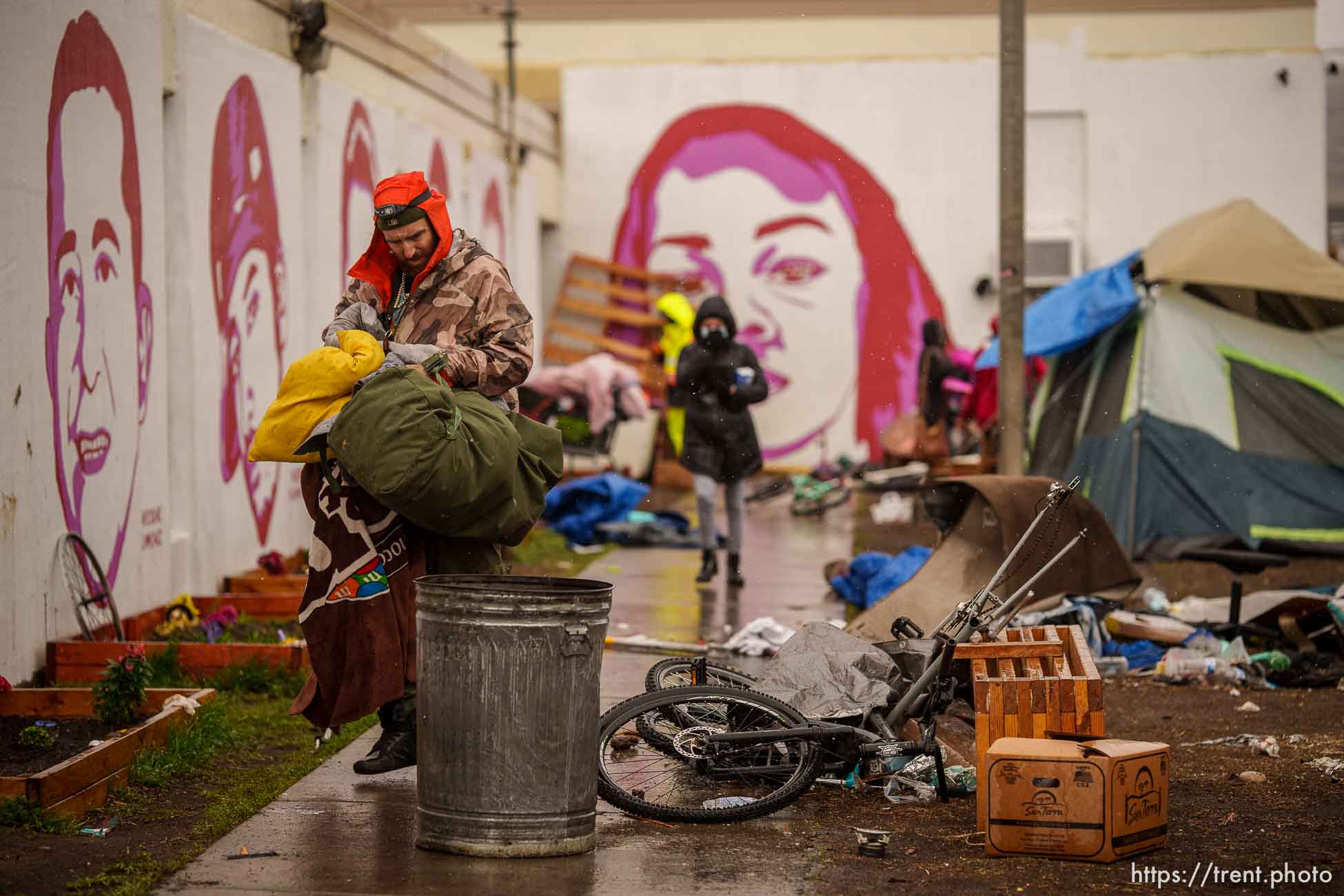 (Trent Nelson  |  The Salt Lake Tribune) People sort through their belongings as Salt Lake County conducts a camp cleanup at the Fleet Block Murals in Salt Lake City on Wednesday, April 14, 2021.