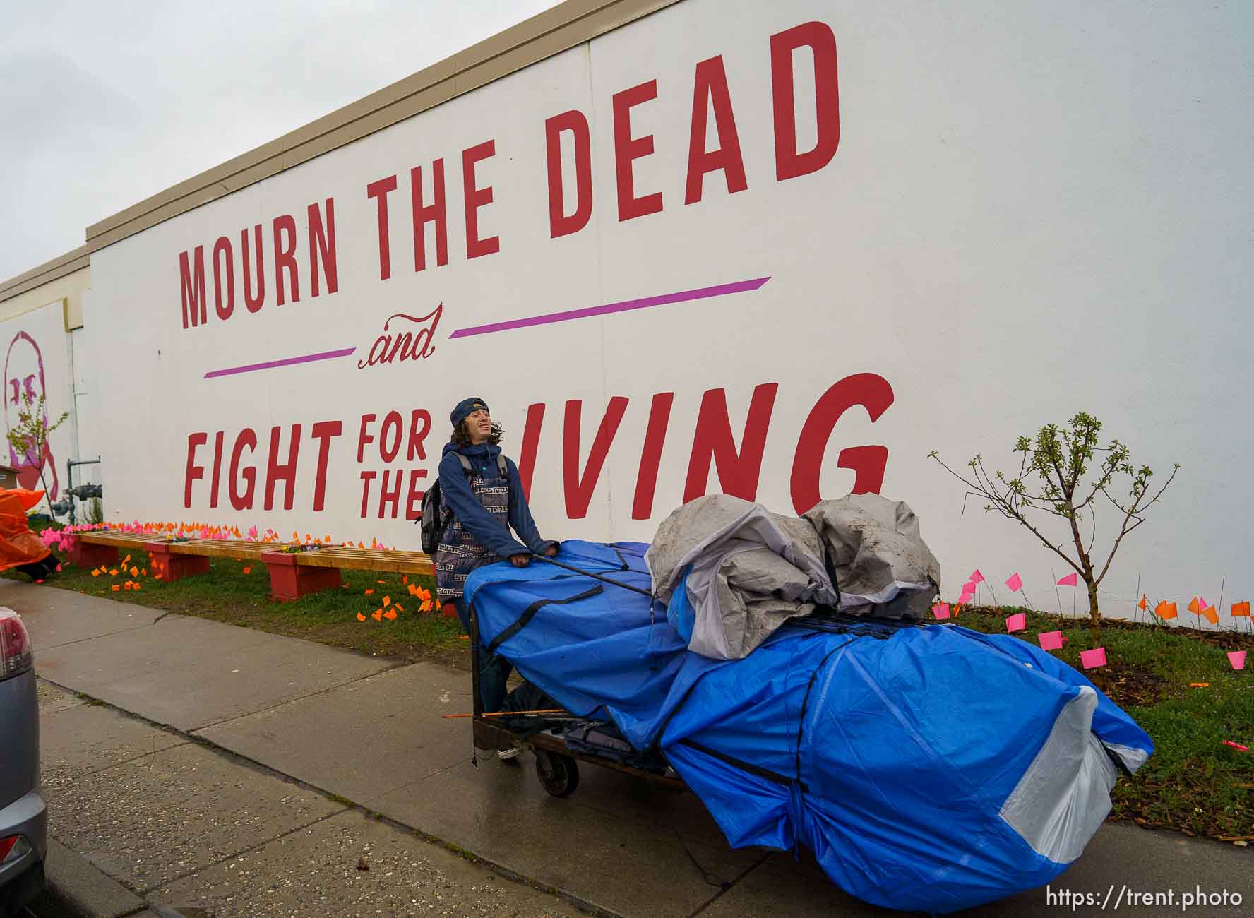 (Trent Nelson  |  The Salt Lake Tribune) A person moves their belongings as Salt Lake County conducts a camp cleanup at the Fleet Block Murals in Salt Lake City on Wednesday, April 14, 2021.