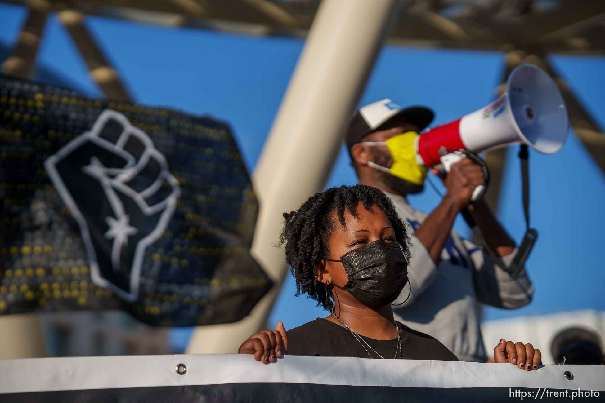 (Trent Nelson  |  The Salt Lake Tribune) Mihiret Burt holds a banner while Mario Mathis speaks at rally at the Public Safety Building in Salt Lake City on Tuesday, April 20, 2021 to mark the conviction of Derek Chauvin for the murder of George Floyd.