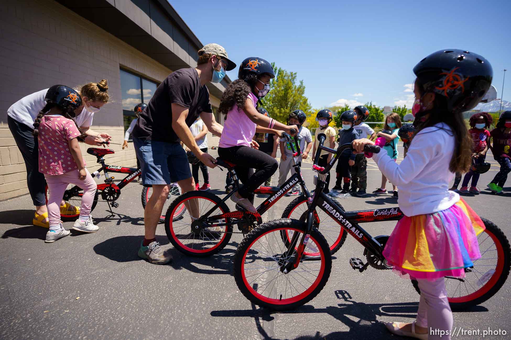 (Trent Nelson  |  The Salt Lake Tribune) Abbi Arneson and Alex Schmidt, volunteers with the non-profit Can’d Aid, hand out sixty bikes to 1st grade students at Mary W. Jackson Elementary in Salt Lake City on Thursday, May 13, 2021.