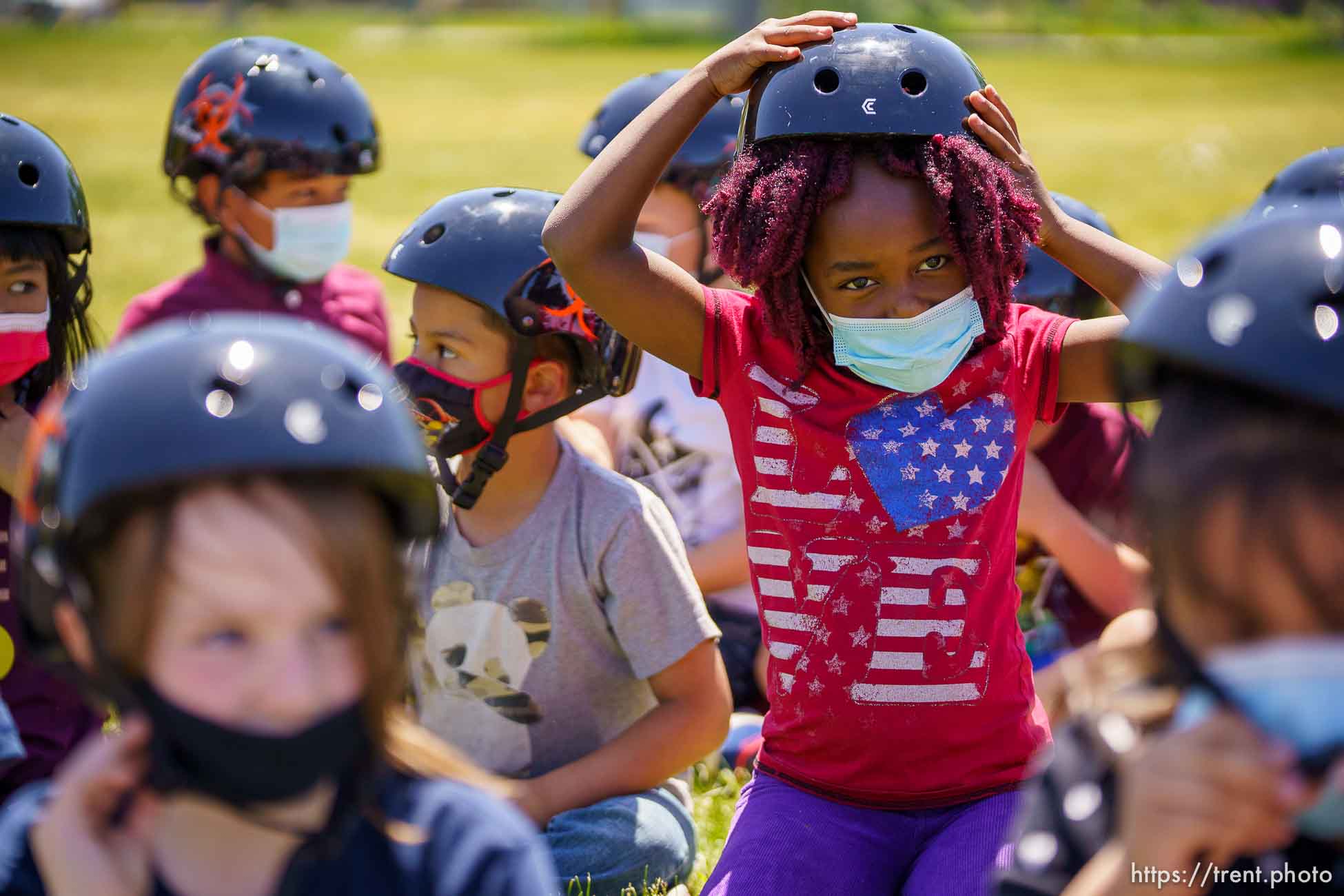 (Trent Nelson  |  The Salt Lake Tribune) 1st grade students at Mary W. Jackson Elementary try on their new helmets as volunteers with Can’d Aid, a non-profit, hand out new bikes in Salt Lake City on Thursday, May 13, 2021.