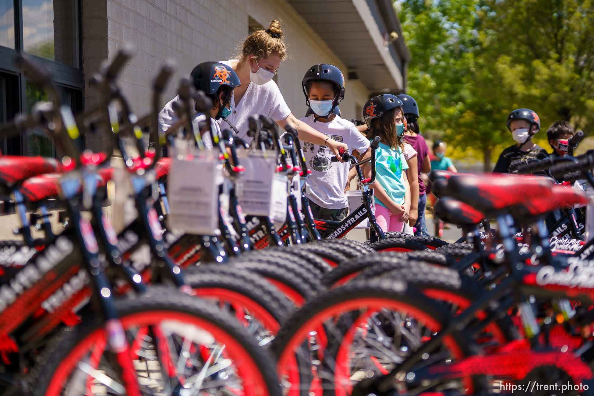 (Trent Nelson  |  The Salt Lake Tribune) Abbi Arneson, a volunteer with the non-profit Can’d Aid, helps to hand out sixty bikes to 1st grade students at Mary W. Jackson Elementary in Salt Lake City on Thursday, May 13, 2021.