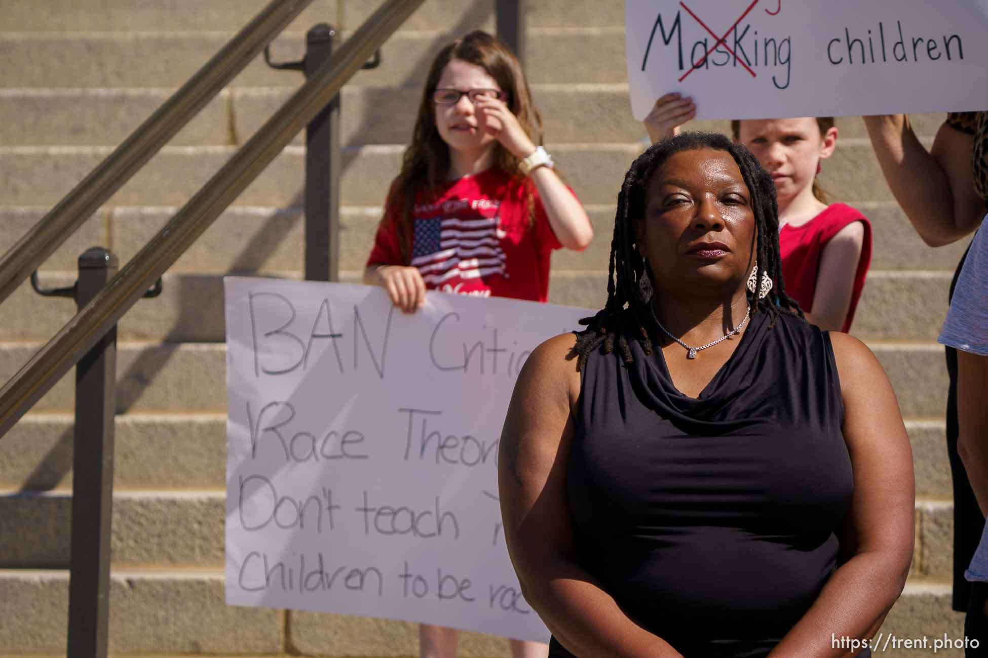 (Trent Nelson  |  The Salt Lake Tribune) Children stand behind Darlene McDonald holding opposing signs during a news conference by the Utah Educational Equity Coalition at the State Capitol in Salt Lake City on Wednesday, May 19, 2021.