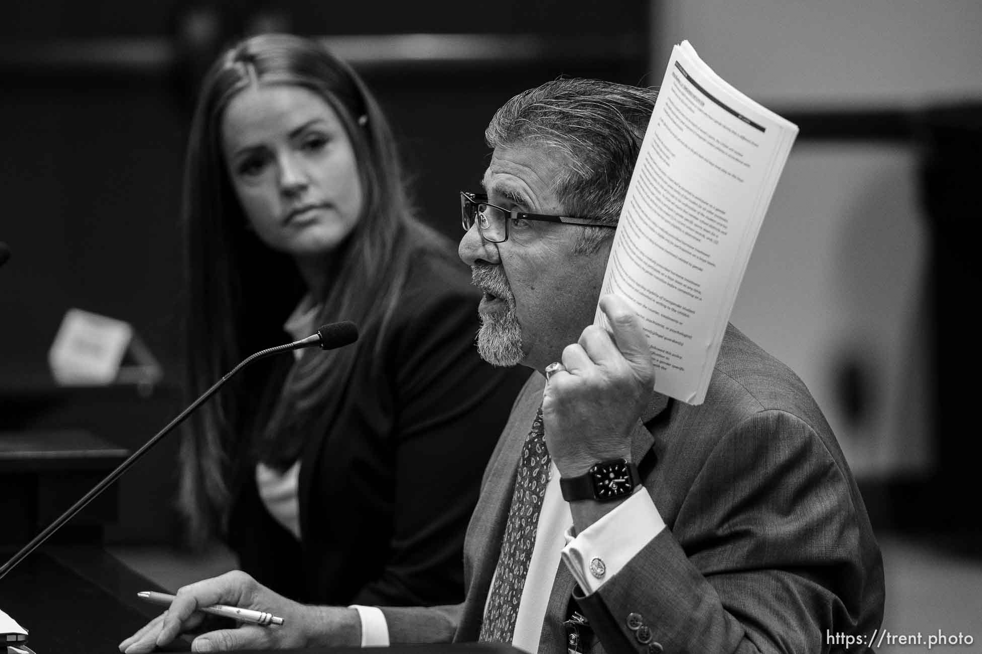 (Trent Nelson  |  The Salt Lake Tribune) Dave Spatafore holds up the UHSAA's policy on transgender athletes, with Rep. Kera Birkeland, R-Morgan, at a meeting of the Health and Human Services Interim Committee at the State Capitol in Salt Lake City on Wednesday, June 16, 2021. Transgender treatment for minors and participation by transgender youth in school sports were the topics of discussion.