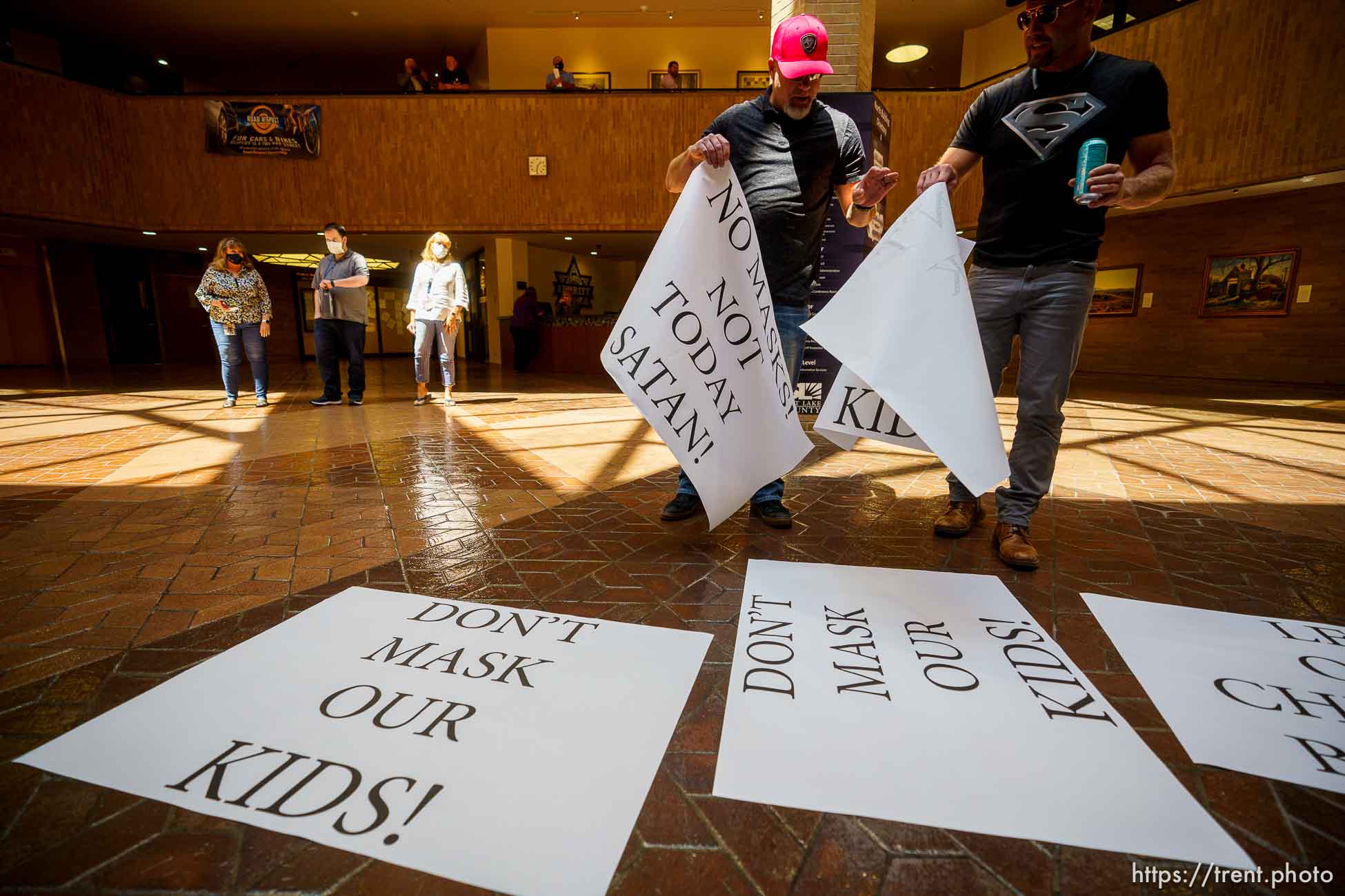 (Trent Nelson  |  The Salt Lake Tribune) Josh Tatum hands out signs as the Salt Lake County Council meets to vote on Dr. Angela Dunn's mask ordinance for K-6 students, on Thursday, Aug. 12, 2021.